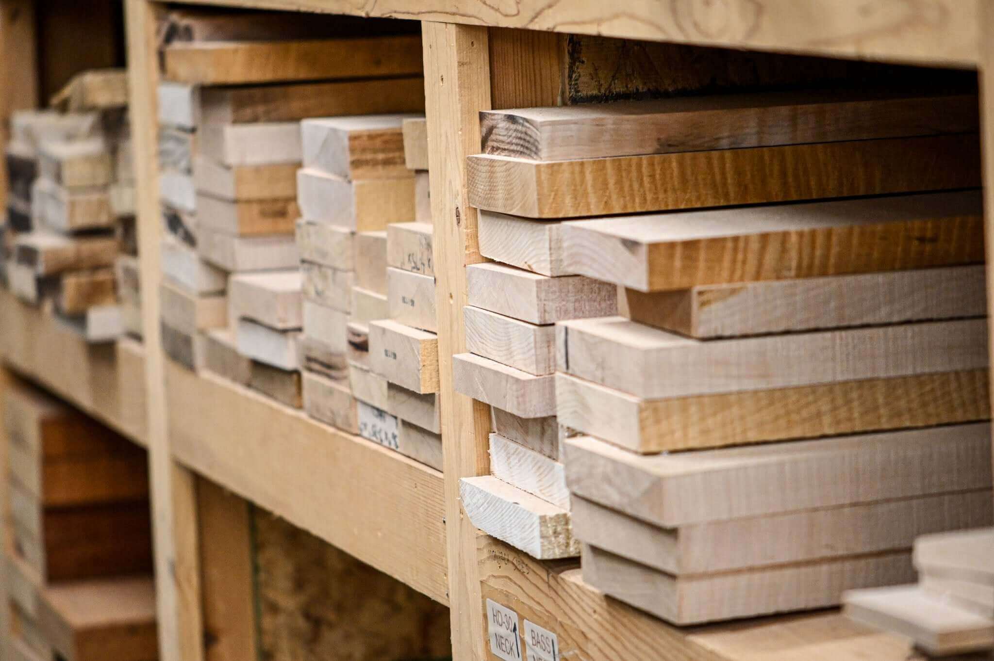 Stacks of tonewoods for solid-body electric guitars, highlighting the truth about tonewoods in solid-body electric guitars.
