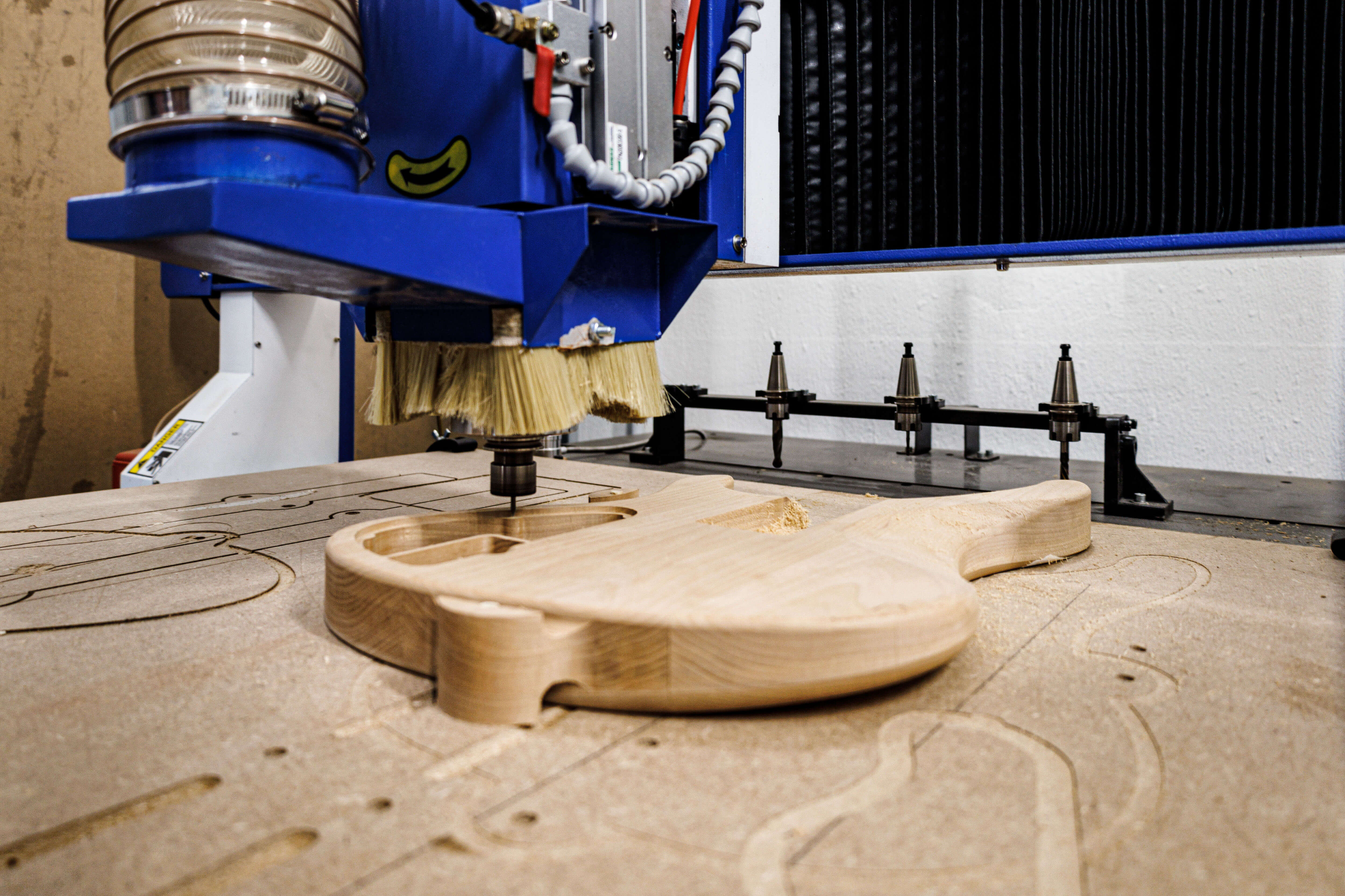 CNC machine carving a wooden guitar body, showcasing Belforti craftsmanship