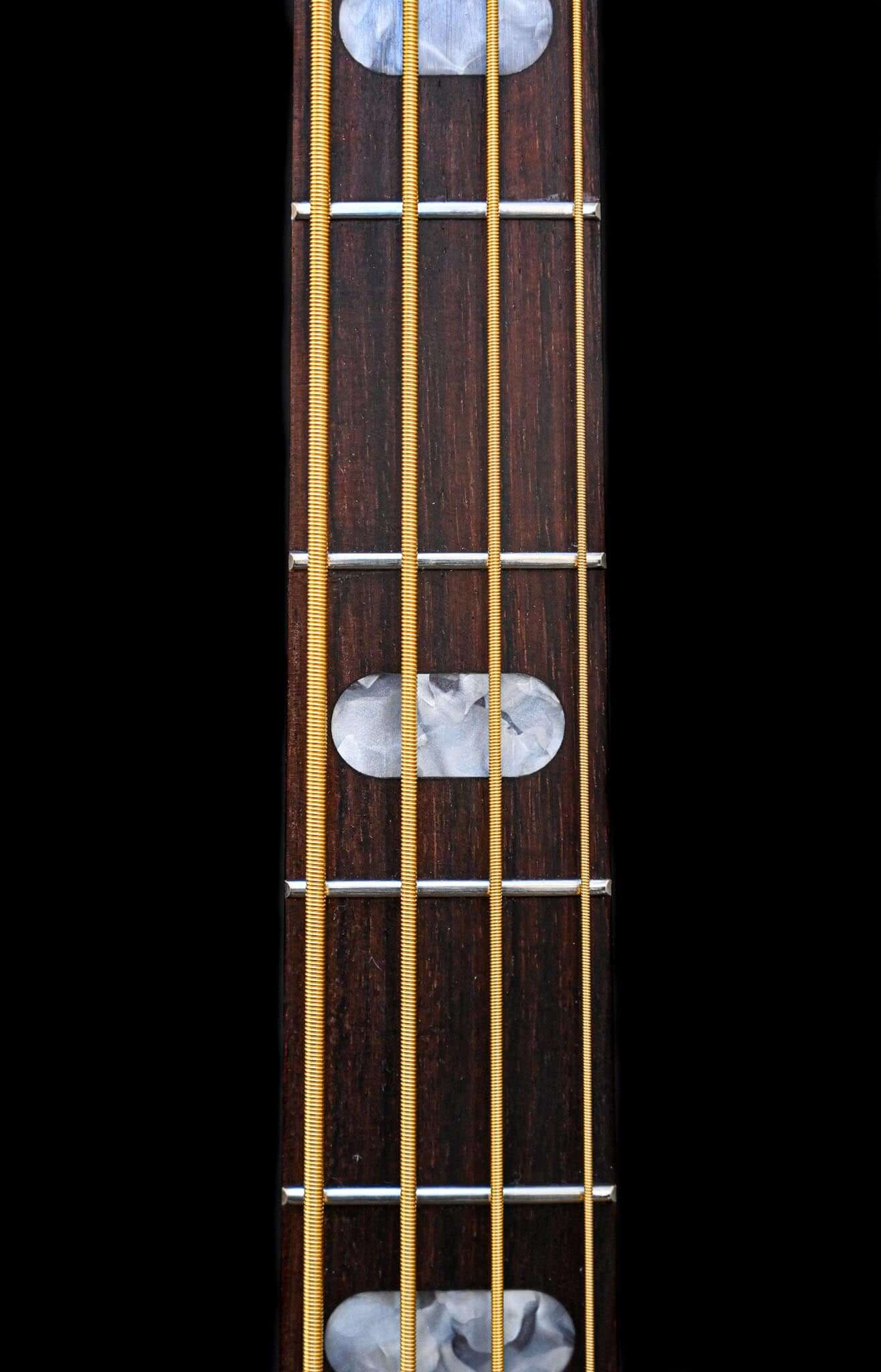 A close view of a Belforti E1 electric bass with 4 strings and perloid inlays