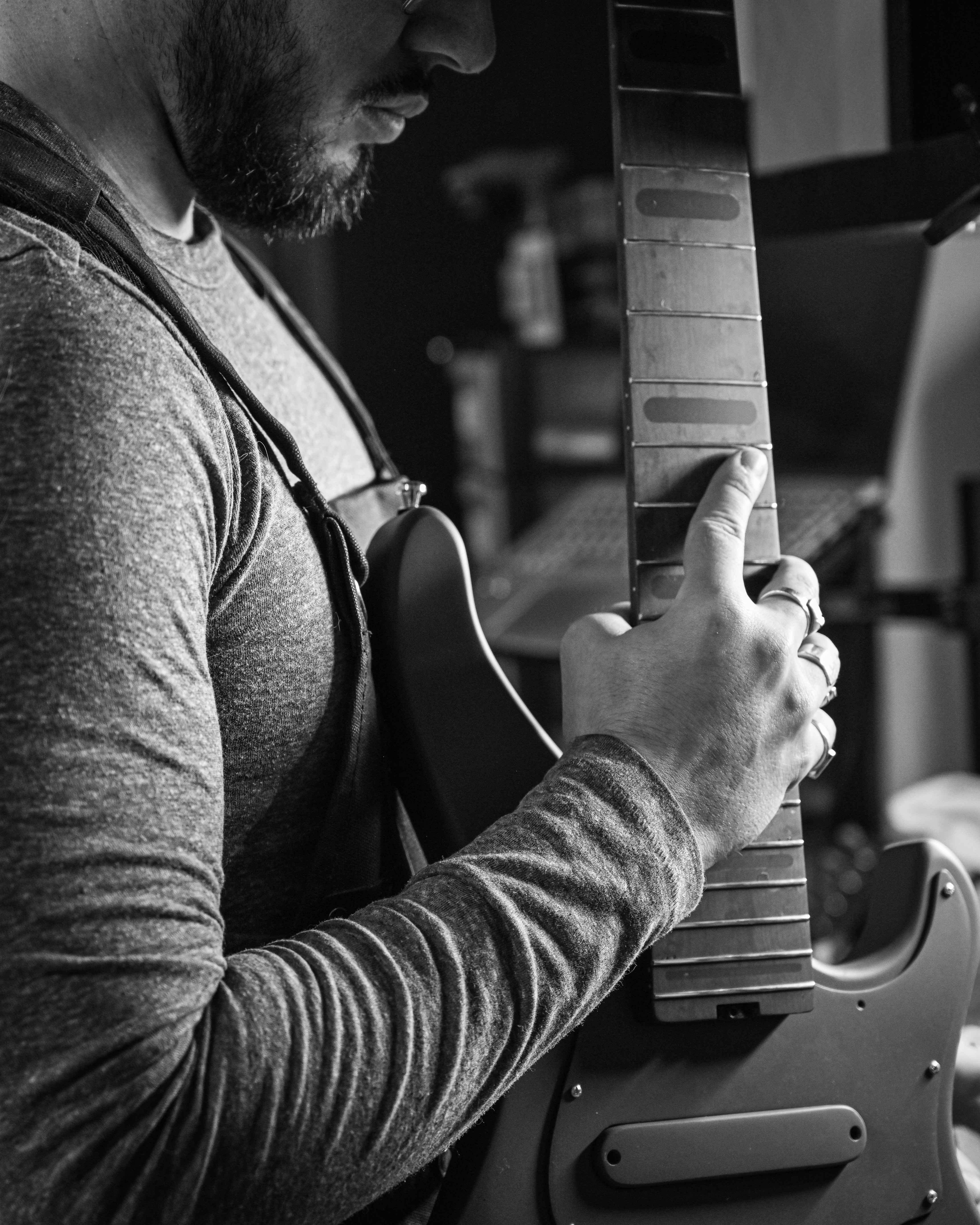 Close-up of a man adjusting guitar strings, showcasing craftsmanship and attention to detail. Keywords: Belforti.