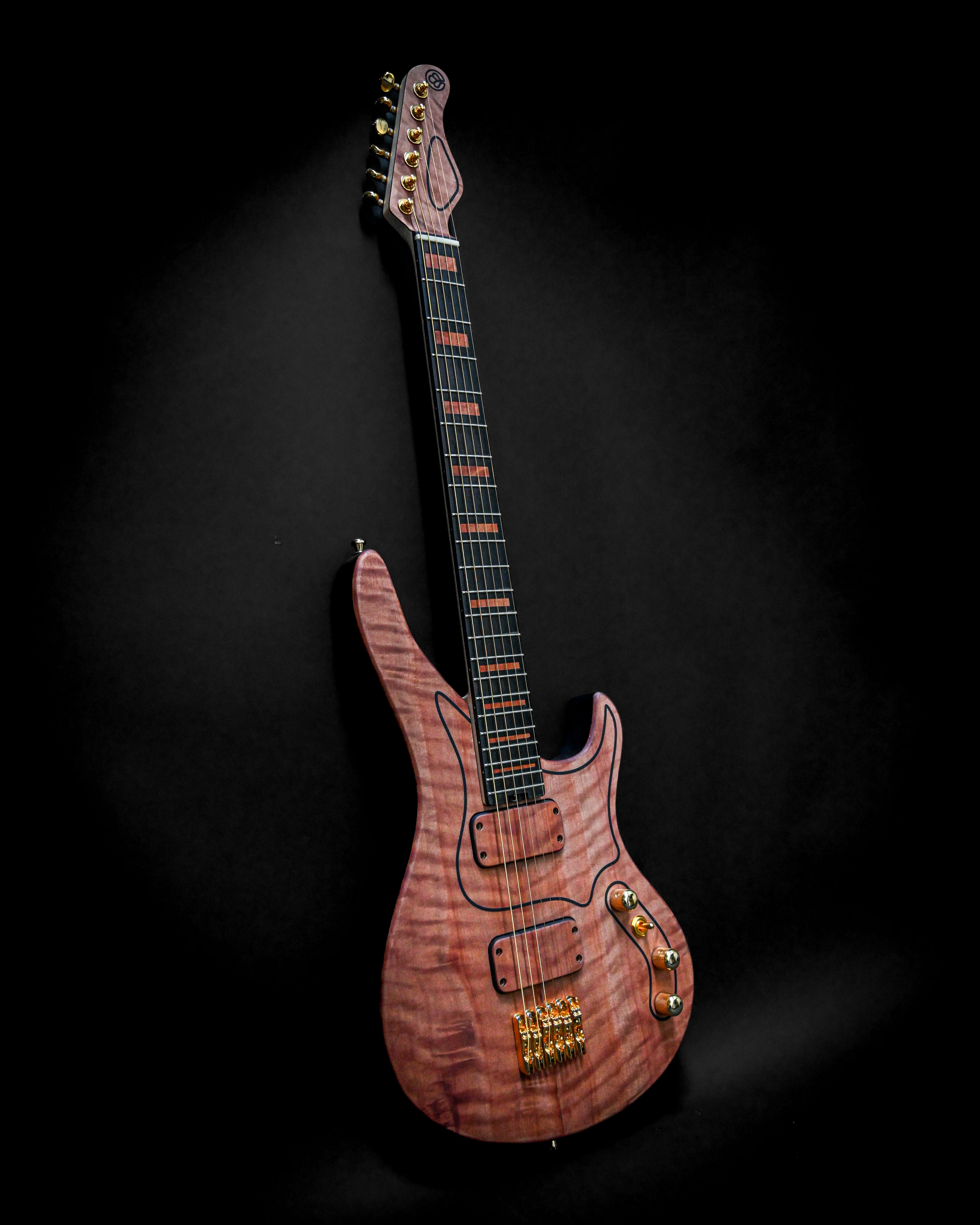 Luxury electric guitar with a maple quilted top on a black background, featuring gold hardware and unique body design.