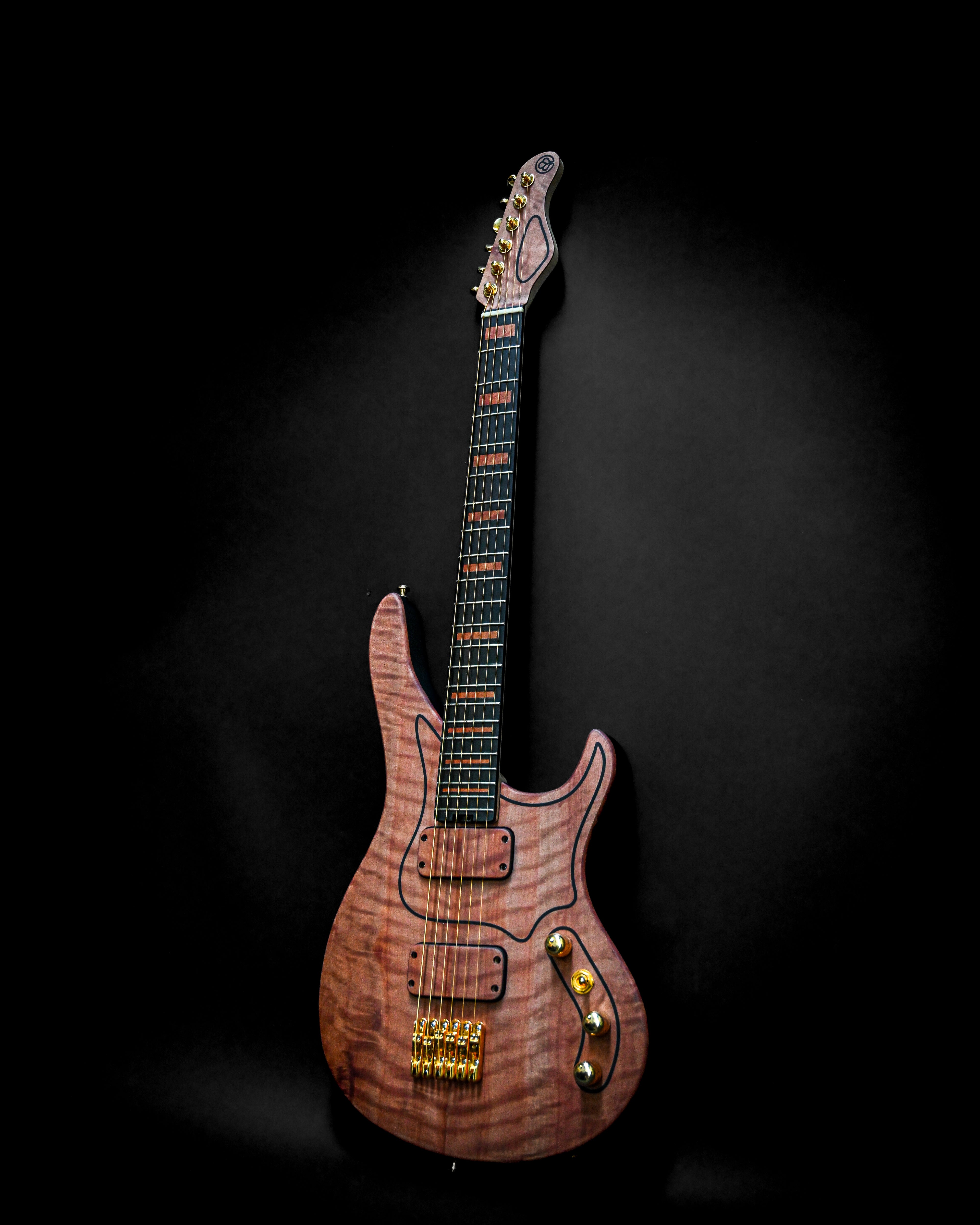 Electric guitar with a sleek wooden finish and gold hardware against a dark background.