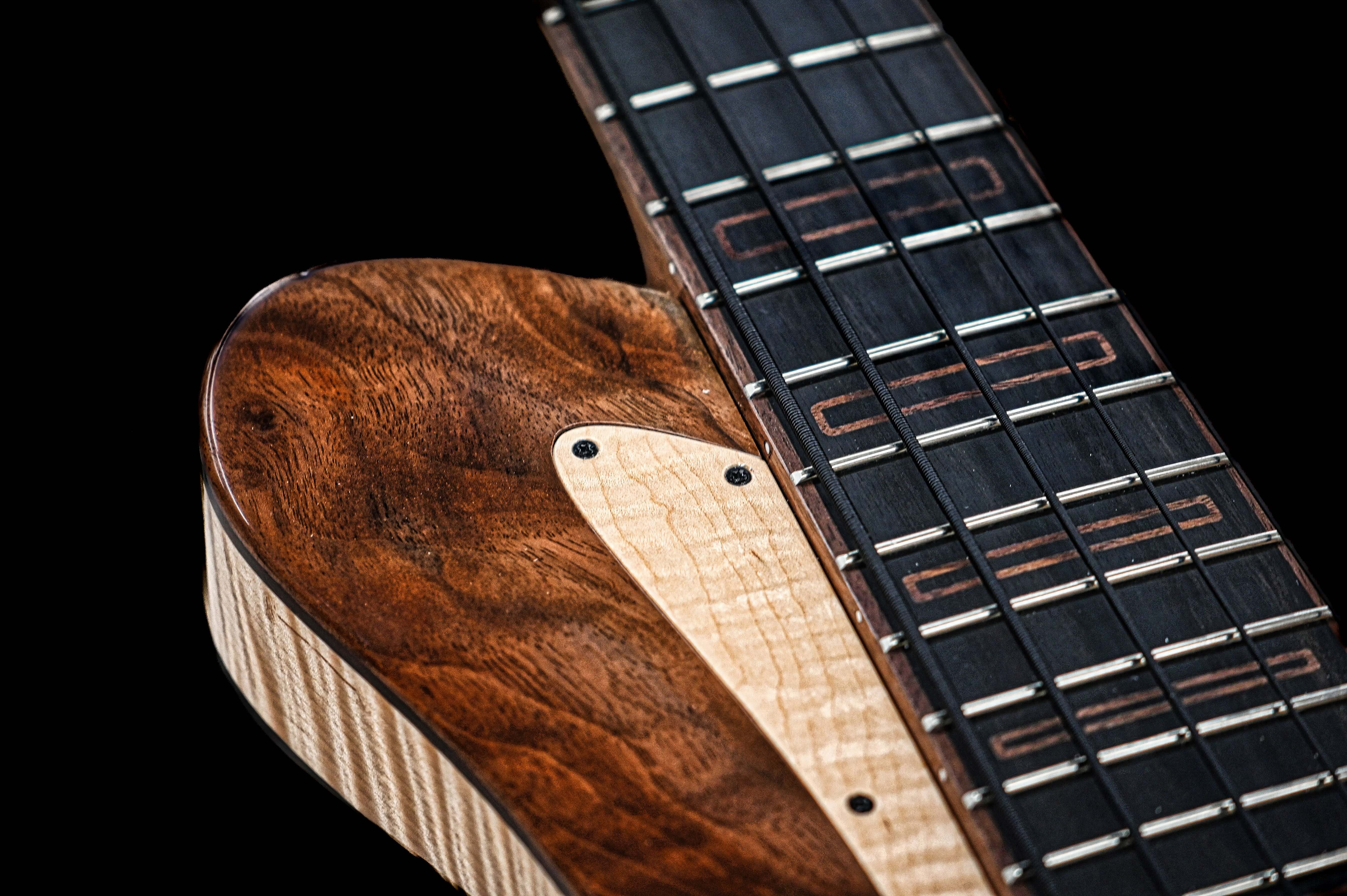 Close-up of a Belforti guitar with a wooden finish and detailed fretboard, showcasing craftsmanship and design elegance.