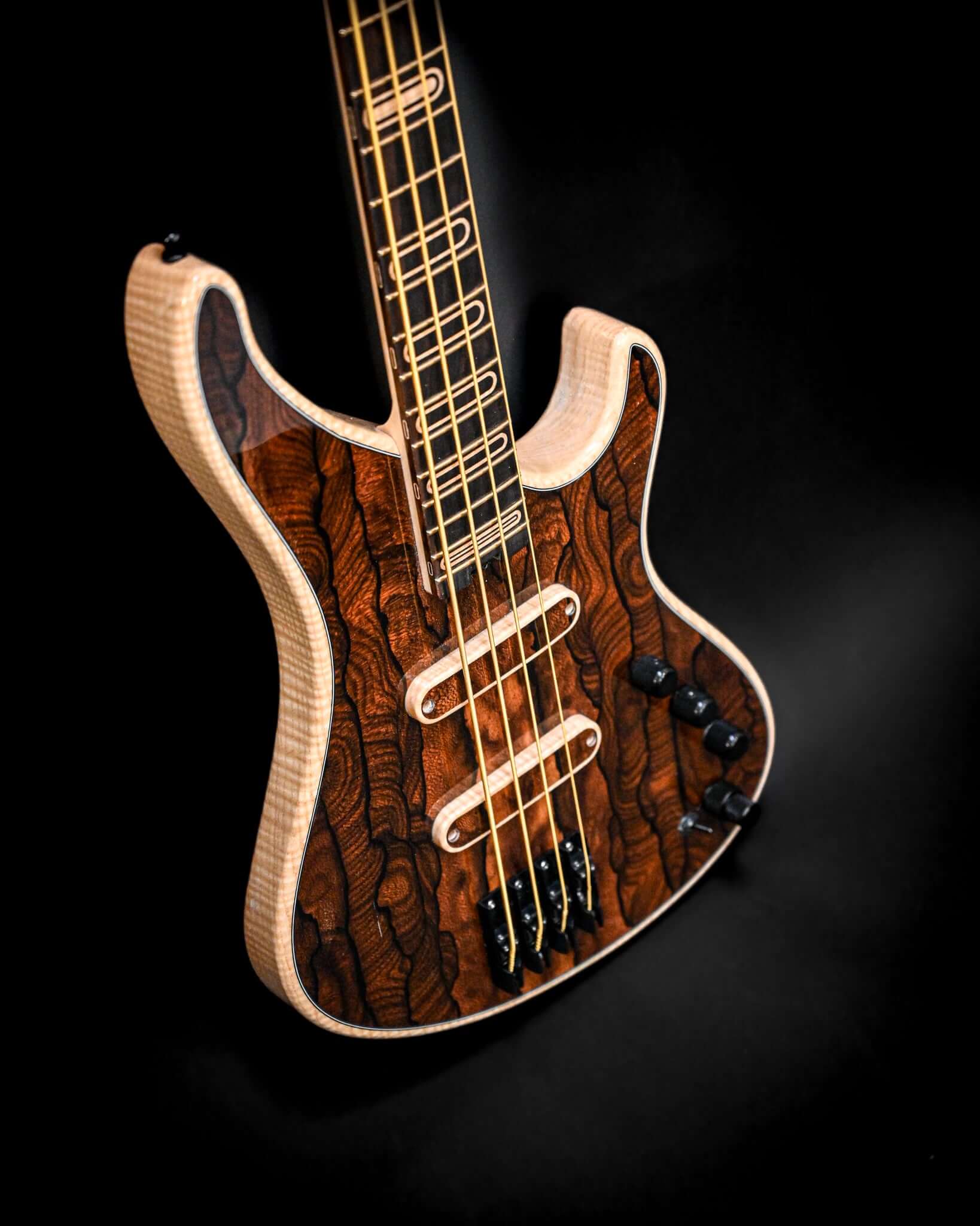 Angled view of the S1 Ziricote electric bass showcasing the intricate grain patterns on its body.