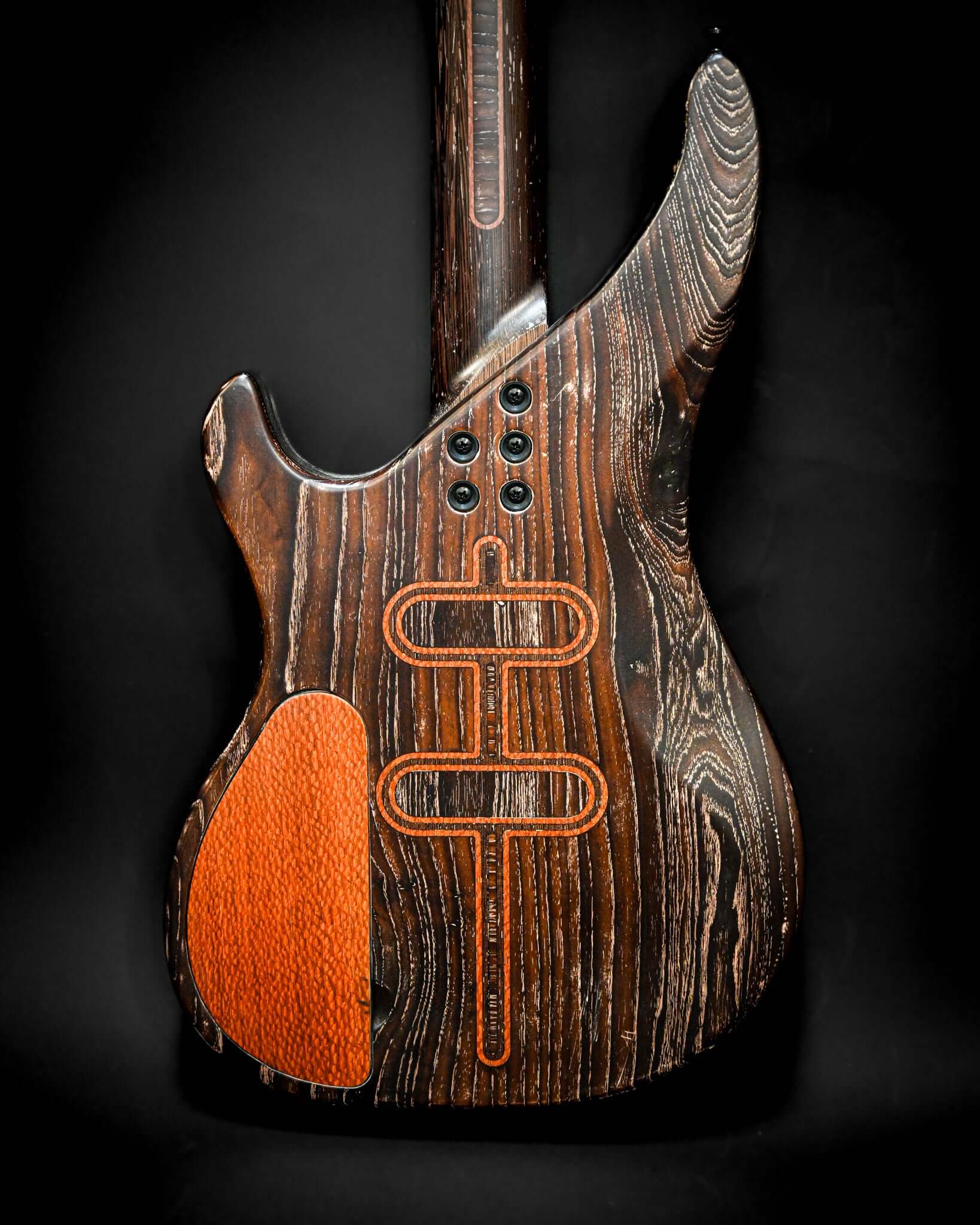Side view of the back of the S3 Lacewood bass guitar, highlighting the stunning wood grain and features.