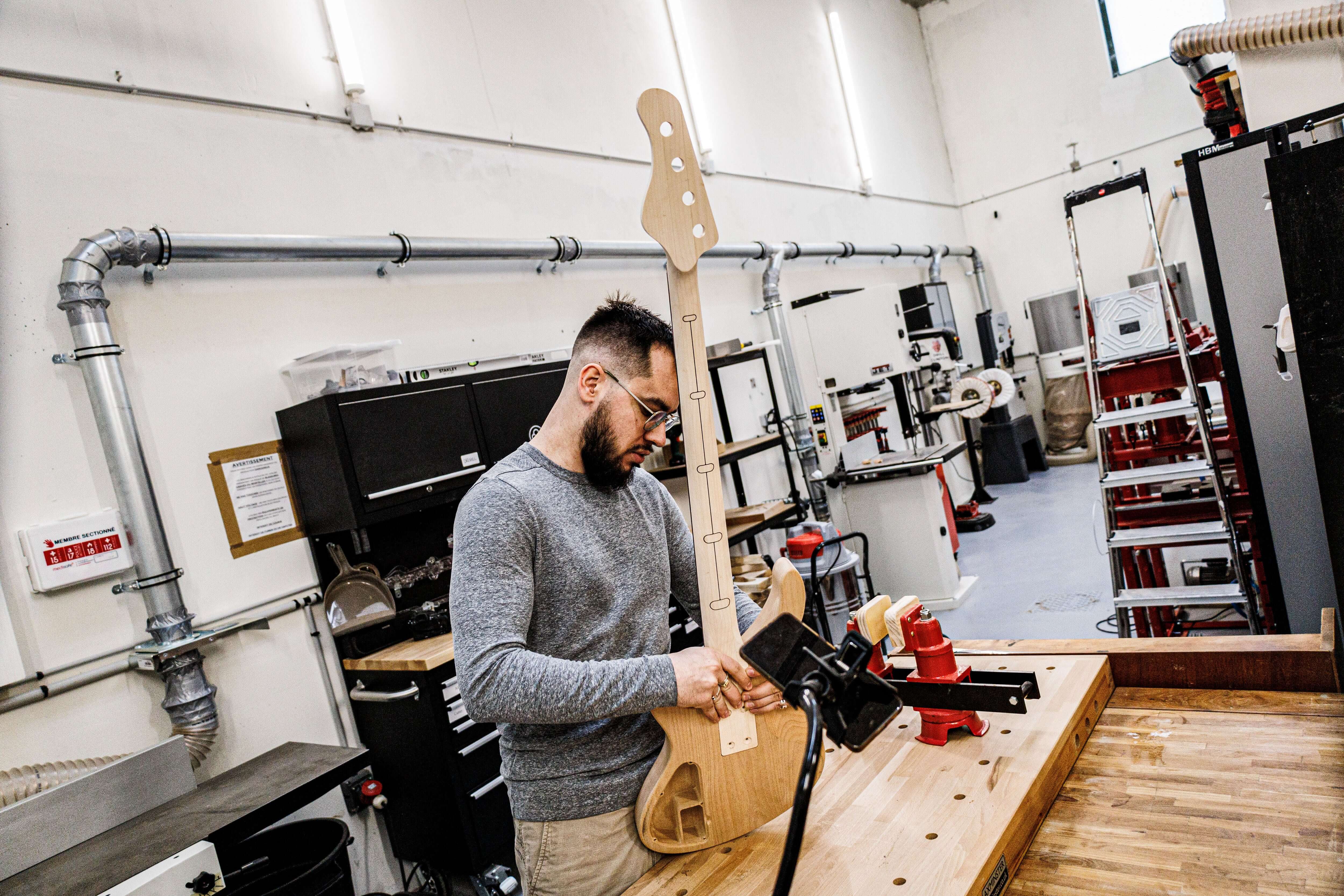 Luthier Marin Nourry-Belforti handworking on a custom boutique E-Series Bass in the Belforti Manufacture, in Paris France