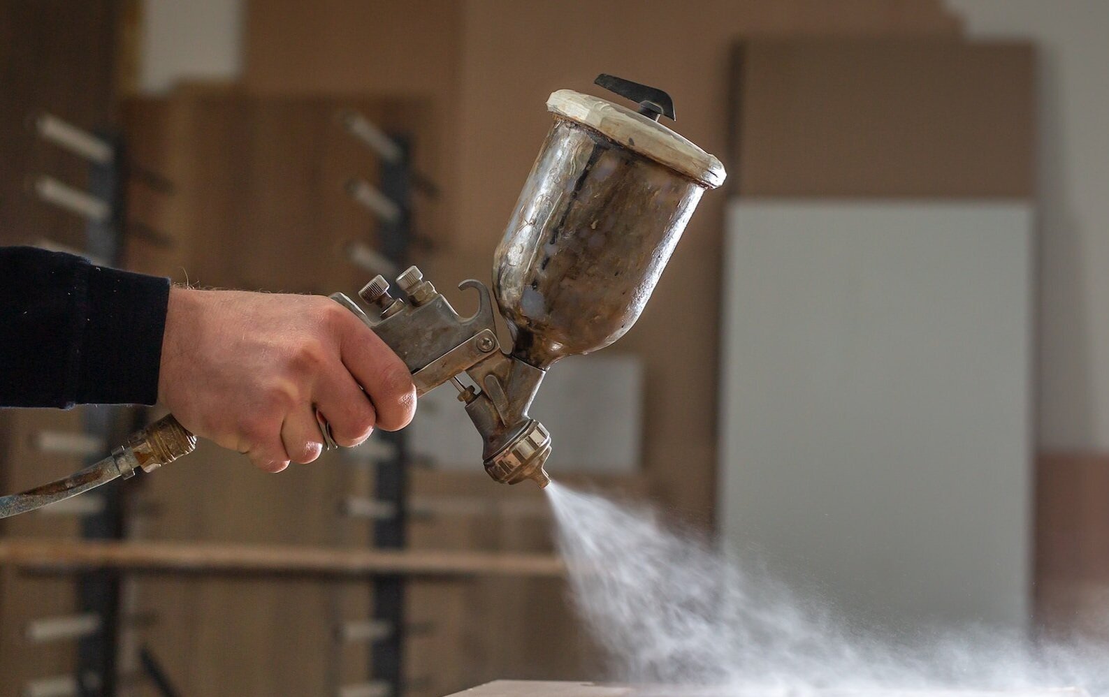 Pistolet à peinture vaporisant de la laque sur une surface