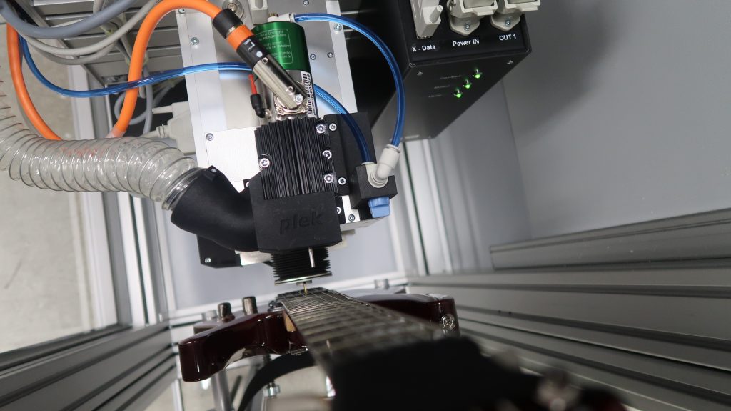 Eine PLEK-Maschine bei der Arbeit an einer Gitarre