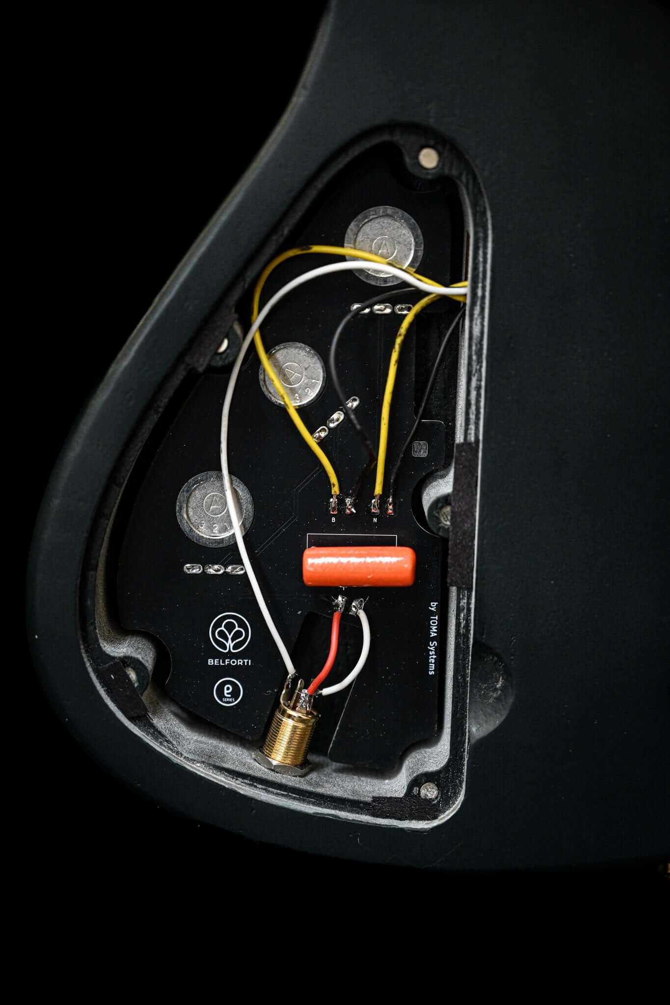 Una toma de primer plano de la cavidad electrónica de un bajo Belforti, que muestra la PCB integrada de Belforti, elaborada y diseñada por TOMA Systems