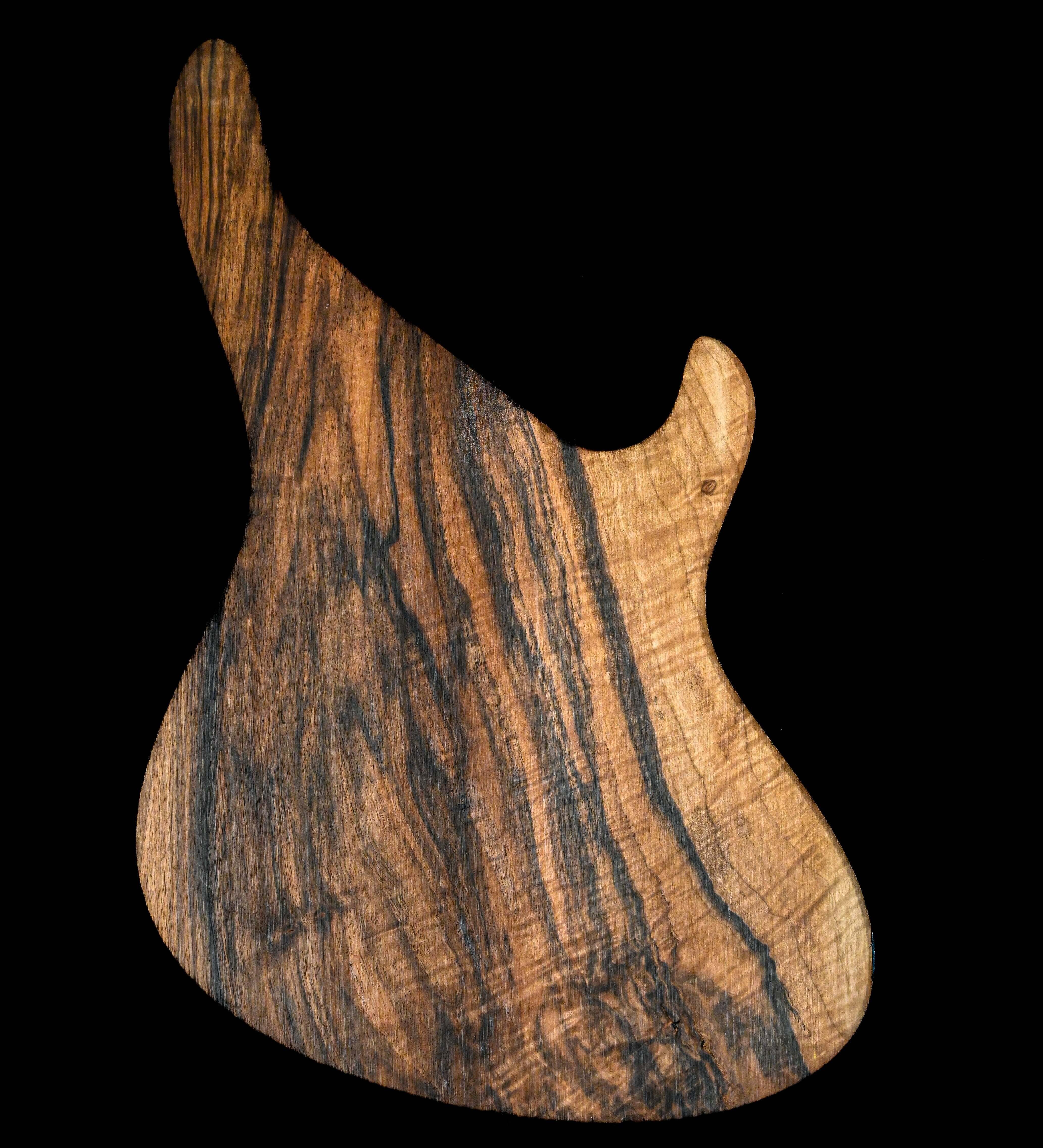 Cuerpo de guitarra Belforti de elaboración artesanal con rica veta de madera sobre fondo negro.