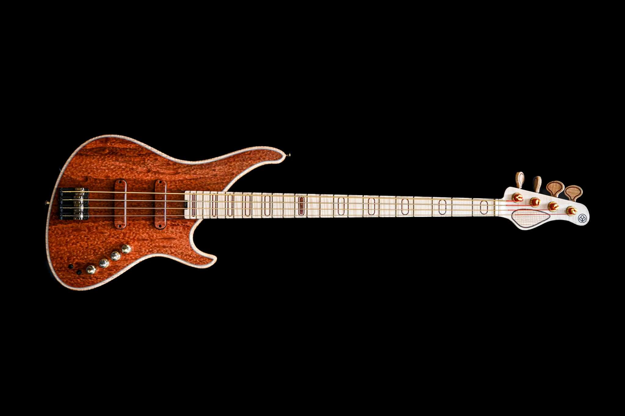 Guitare basse électrique personnalisée avec finition en bois et conception complexe de la touche sur fond noir.