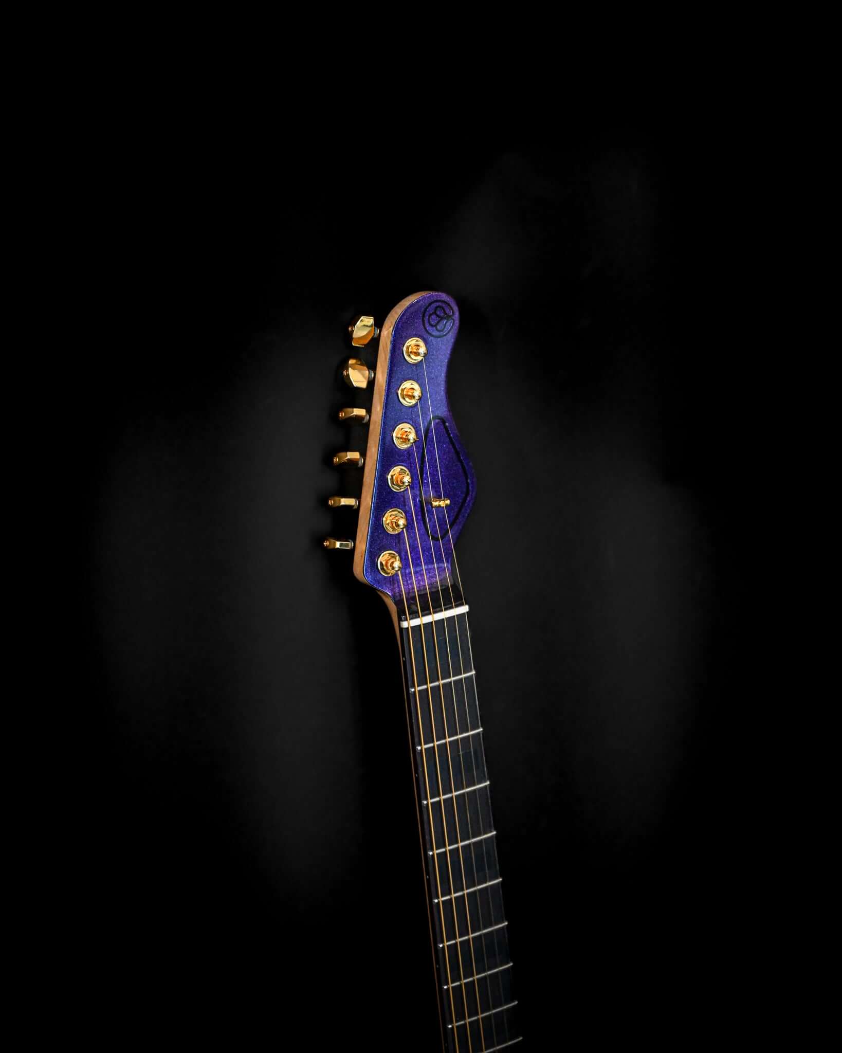 Gros plan de la tête de la guitare E7 - Cosmo (Colorshift) présentant une quincaillerie dorée et une finition de couleur dynamique.