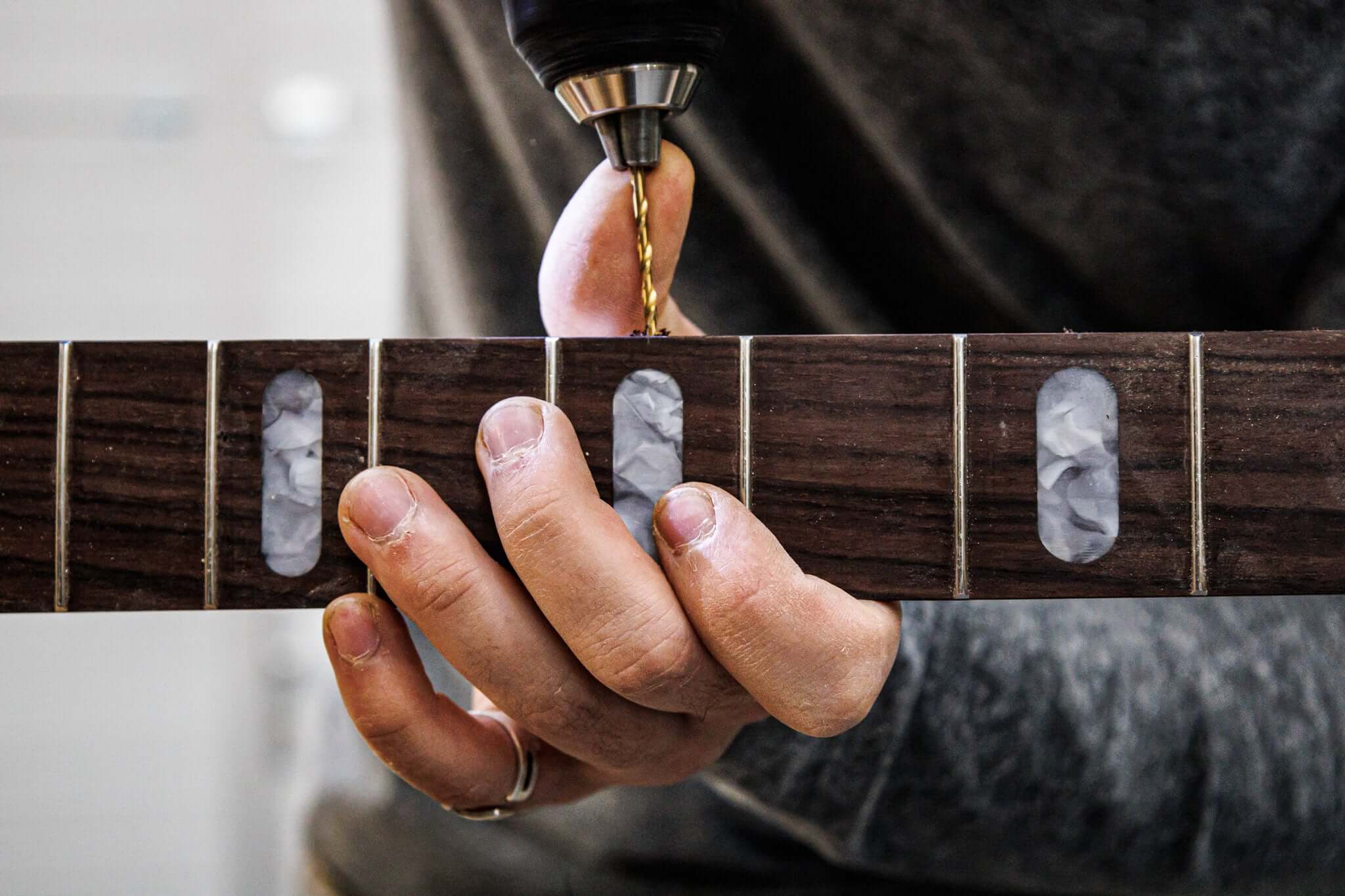 Le luthier Marin Nourry Belforti perce des repères de touche sur une basse électrique Belforti