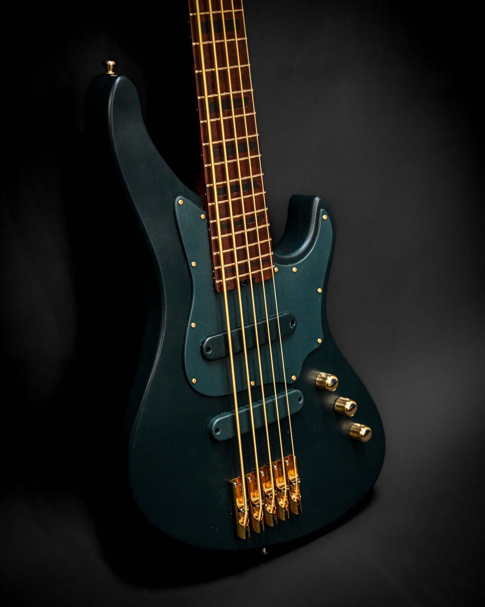 Belforti Instruments提供のE1 Vosges Pine Greenベースギターのダイナミックなアングル。ユニークな輪郭が際立っています。