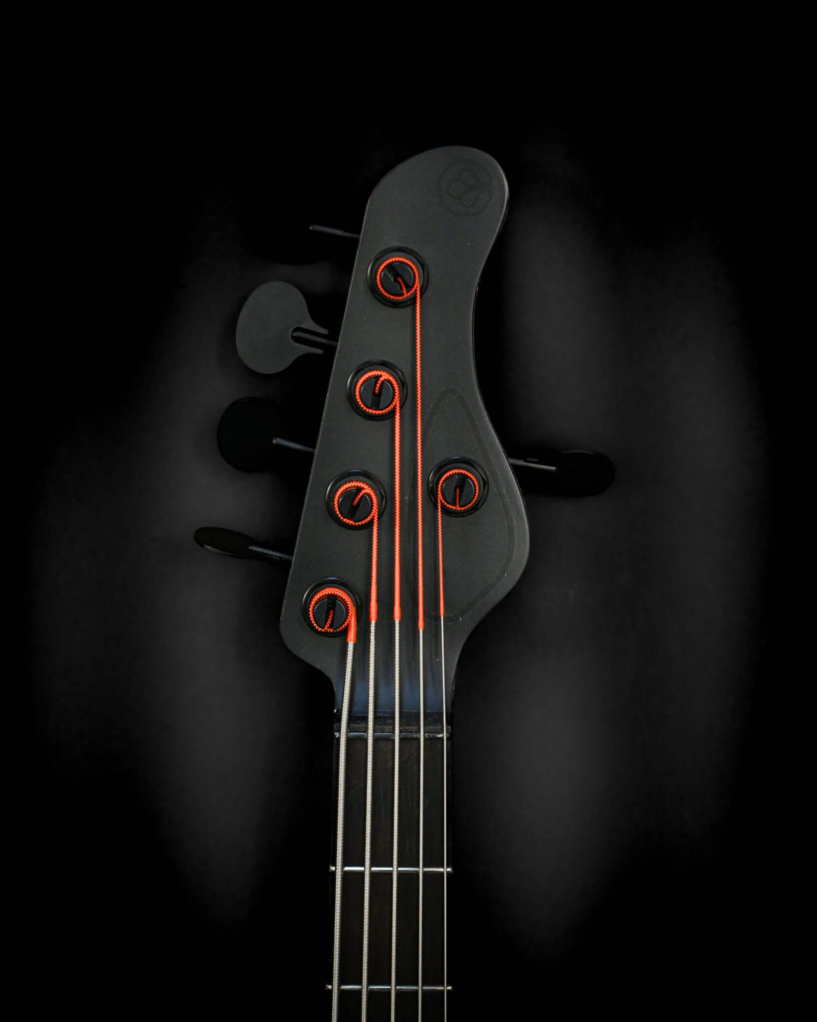 Belforti InstrumentsのE3 Lorraine Coalベースギターのヘッドストックのクローズアップ。鮮やかなオレンジ色のアクセントが施されたチューニングペグが特徴です。