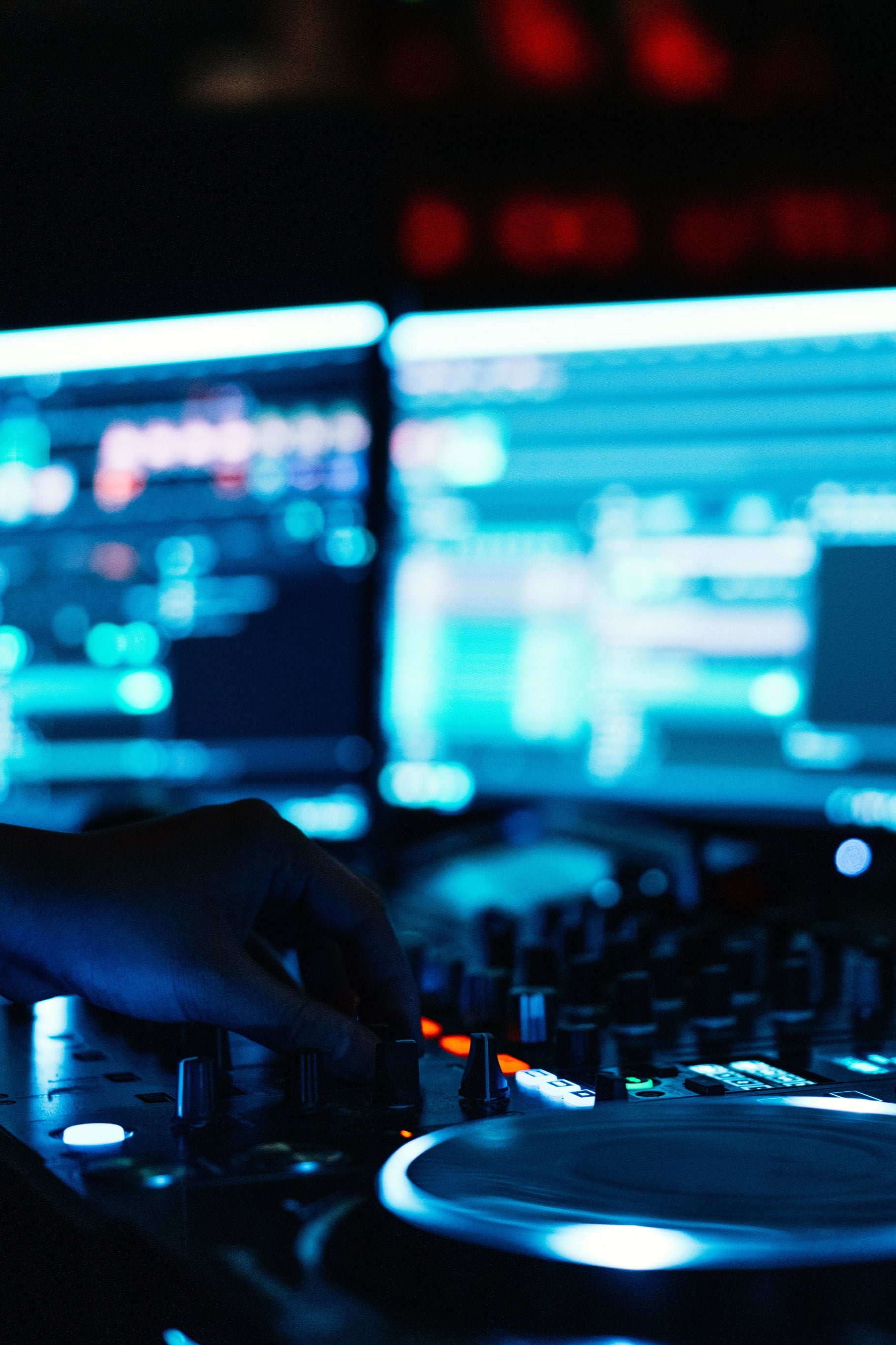 DJセットで作業する手の暗いクローズアップ