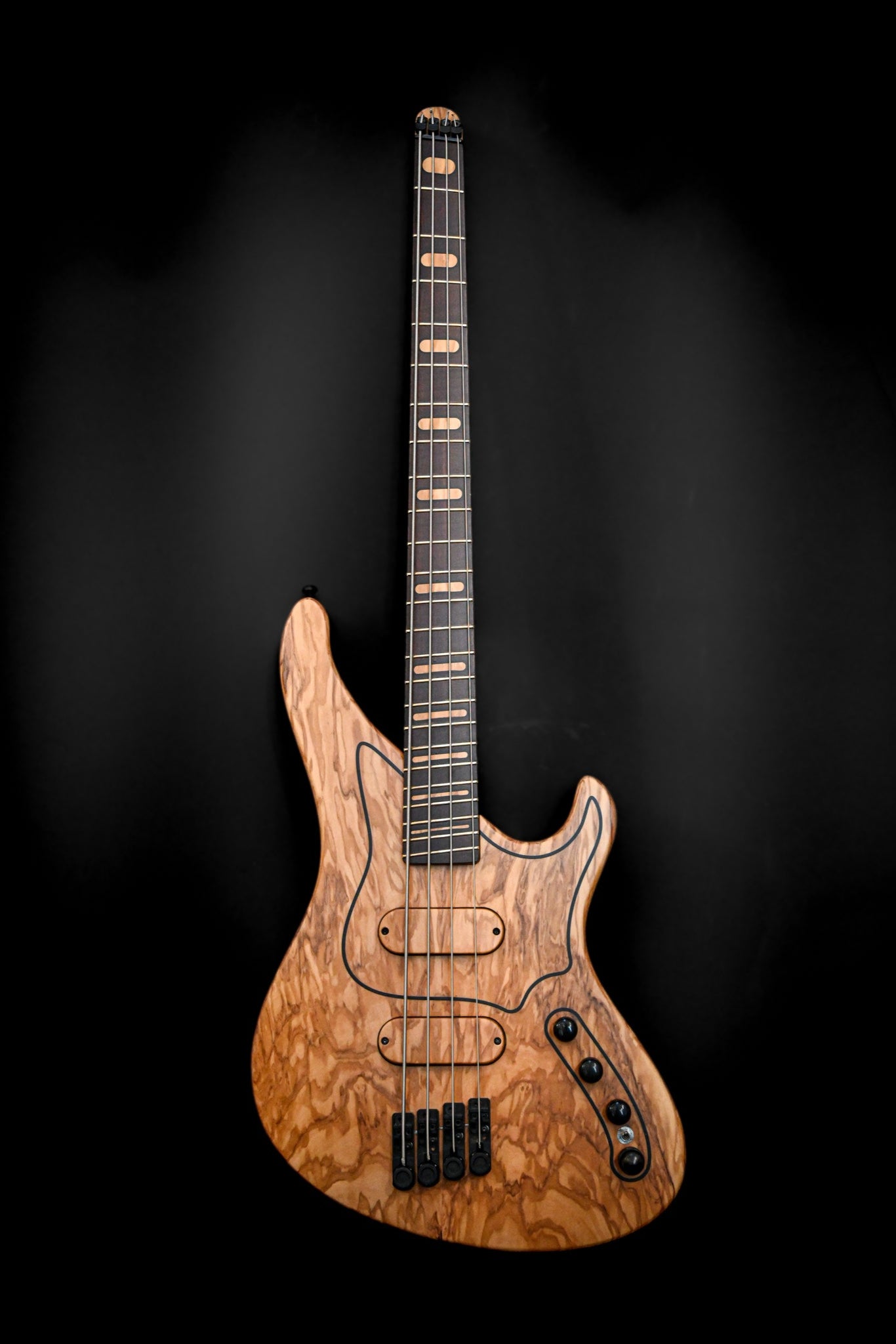 Grande plano do baixo Custom da série M, com pormenores intrincados do grão da madeira e da escala, fabricado à mão pela Belforti Instruments.