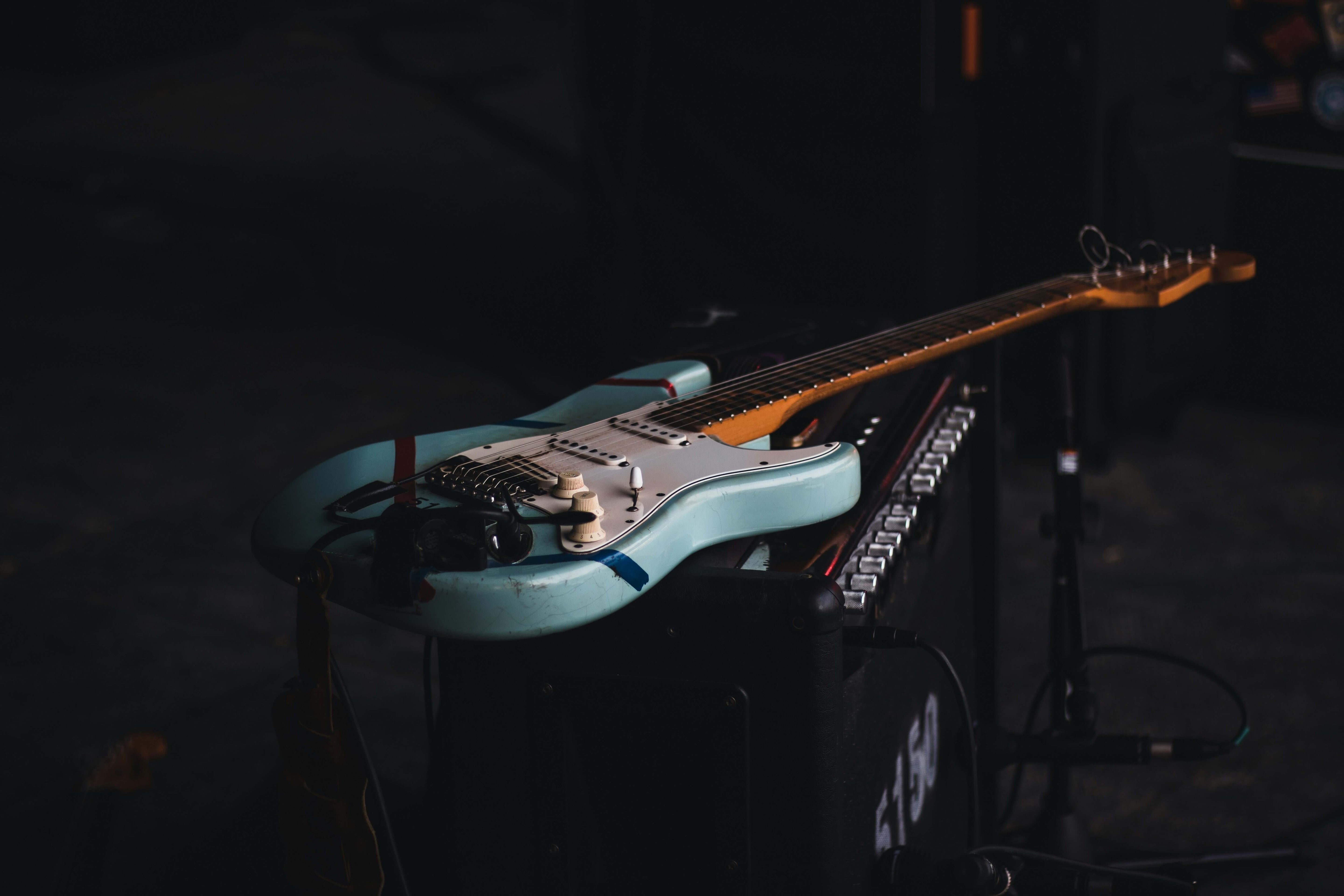 Electric guitar resting on an amp, possibly showing signs it needs a setup. Top 5 signs your guitar needs a setup.
