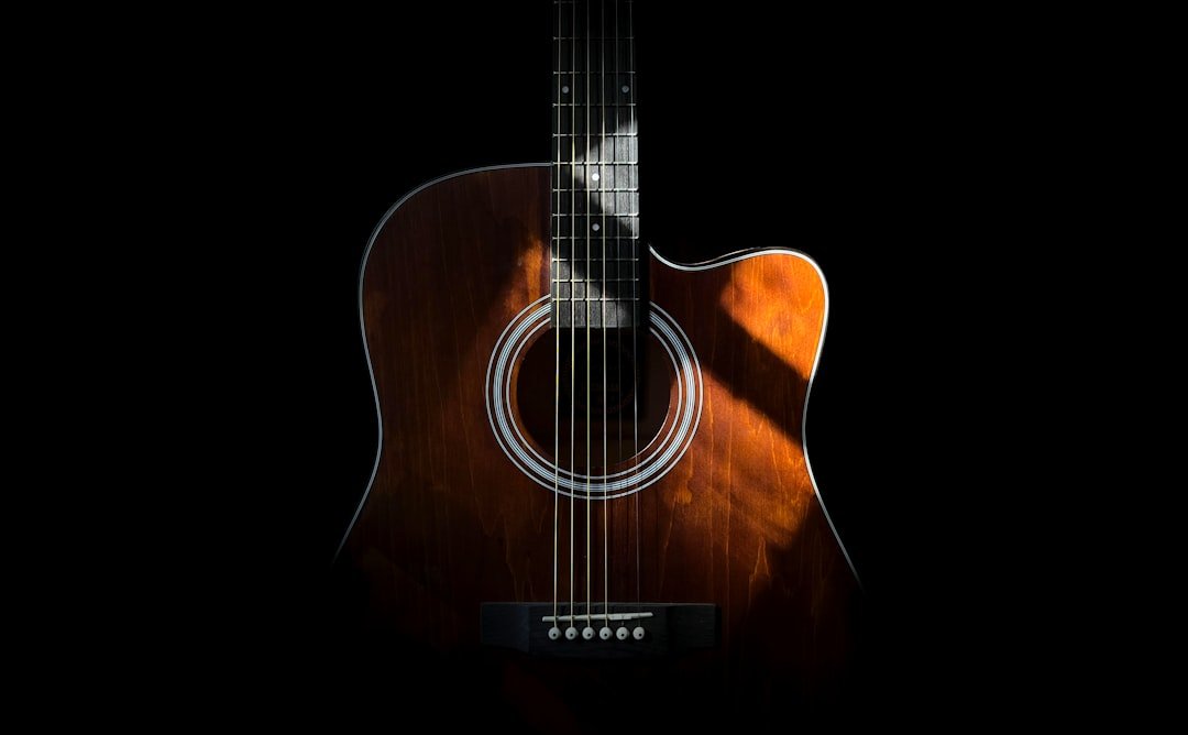 Une photo recadrée d'un corps de guitare acoustique avec un éclairage de studio.