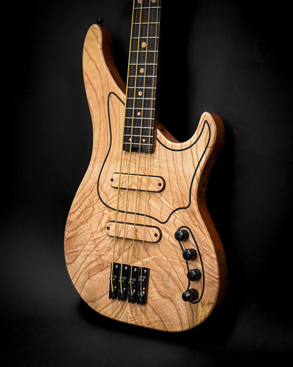 M-Series Belforti M3 Maple Bass Custom showcasing stunning woodwork and craftsmanship from Belforti Instruments, posed on a black background.