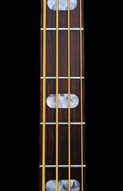Close view of a Belforti Mare 4 Essential fretboard, showing perloid inlays, gold strings, and indian rosewood fretboard