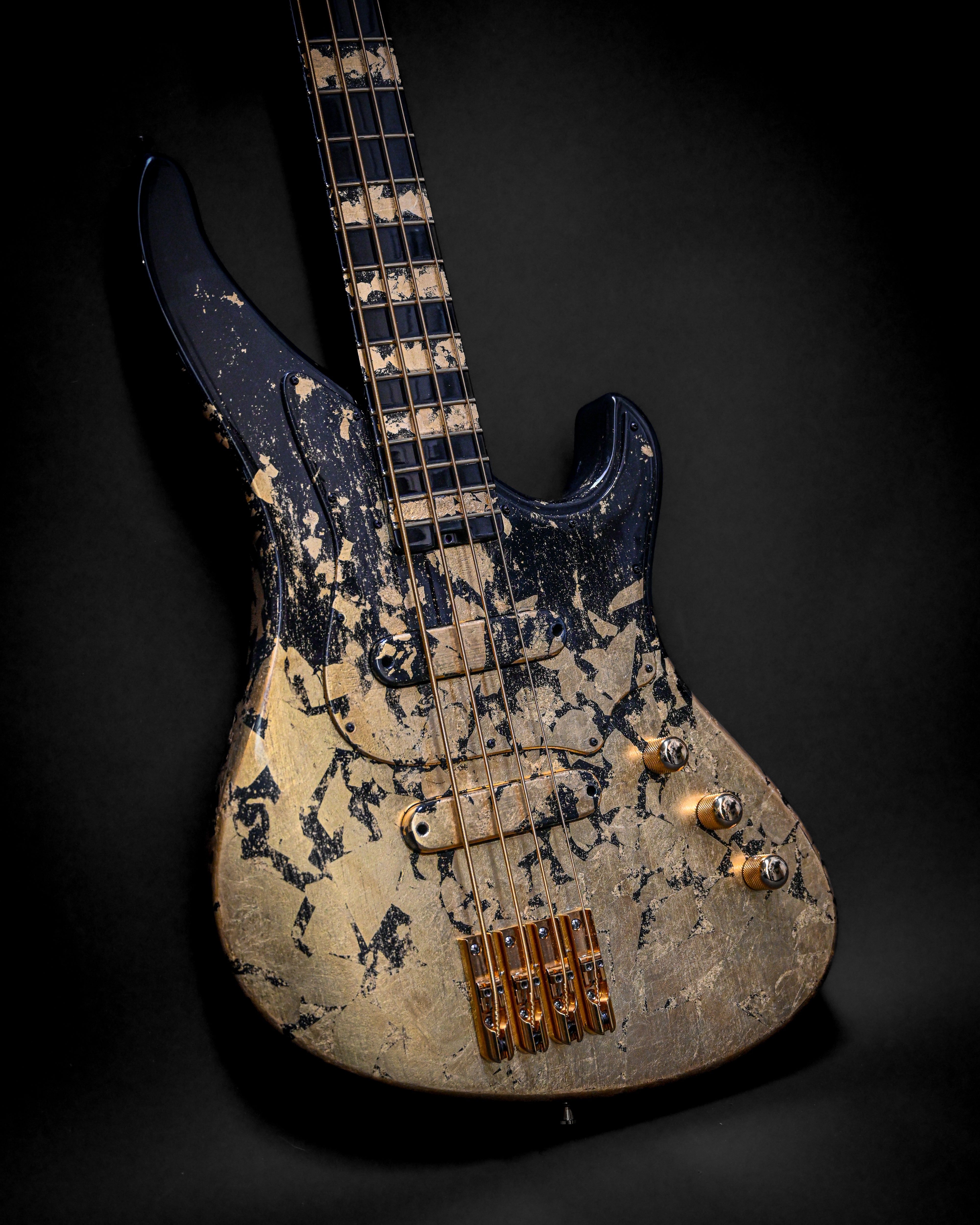 Vintage electric bass guitar with distressed finish and four strings on a dark background.