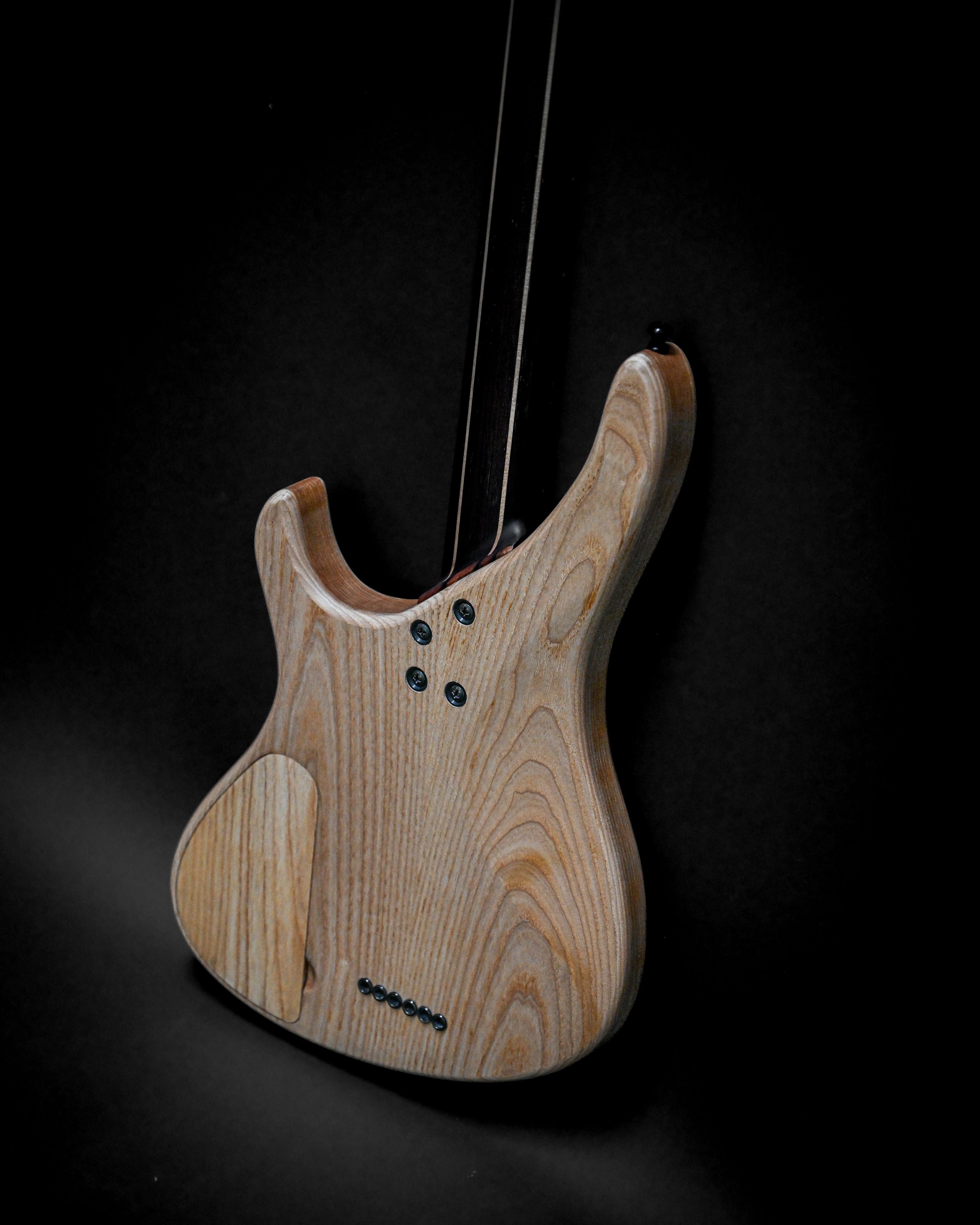 Rear view of Sarā 6 - Masterbuilt custom electric guitar showcasing fine wood grain and craftsmanship.