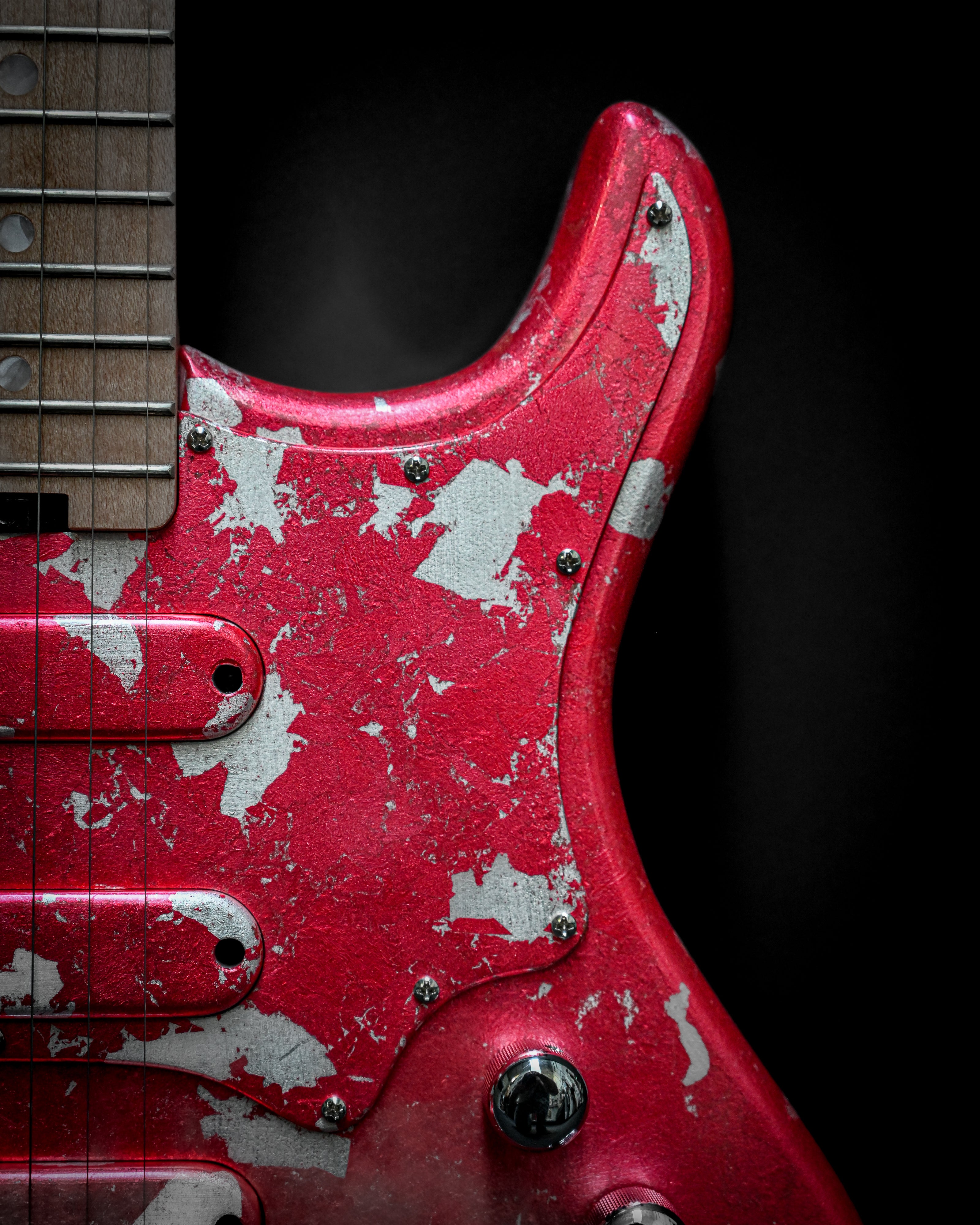Close-up of Yatē 6 - Essential - Kurenai custom electric guitar body and neck with red finish and weathered details.