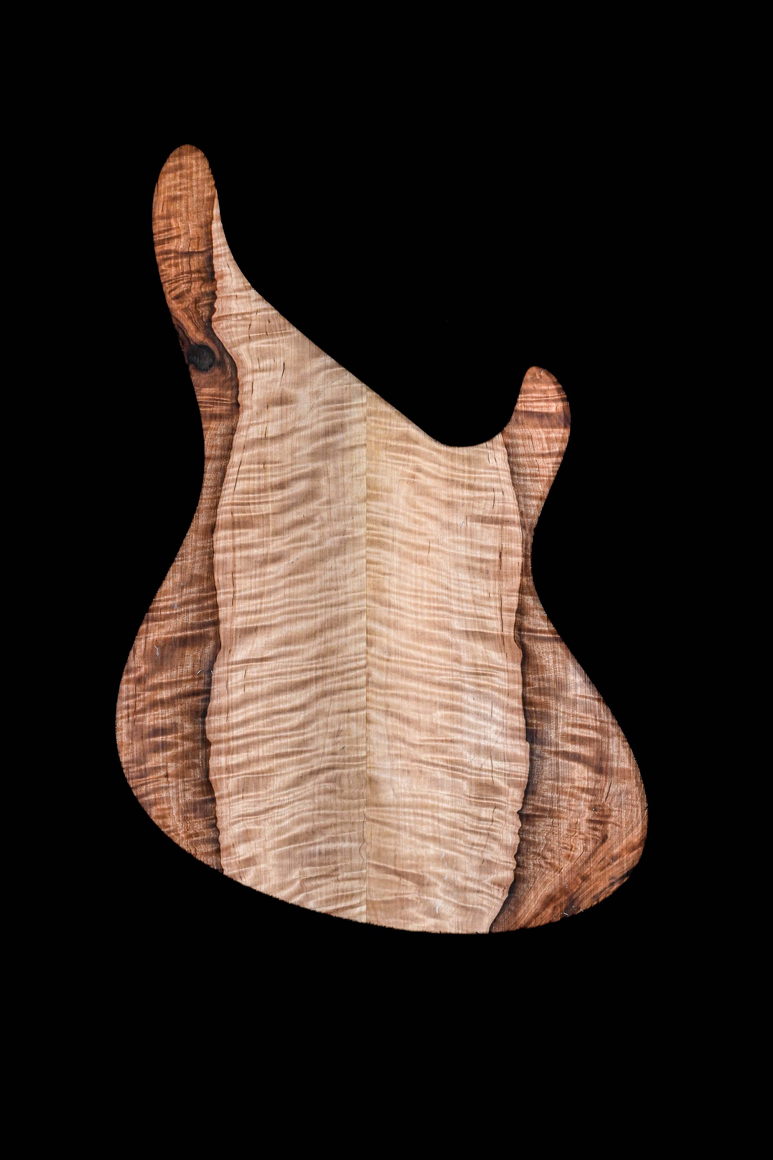 Curly maple and walnut guitar body on black background