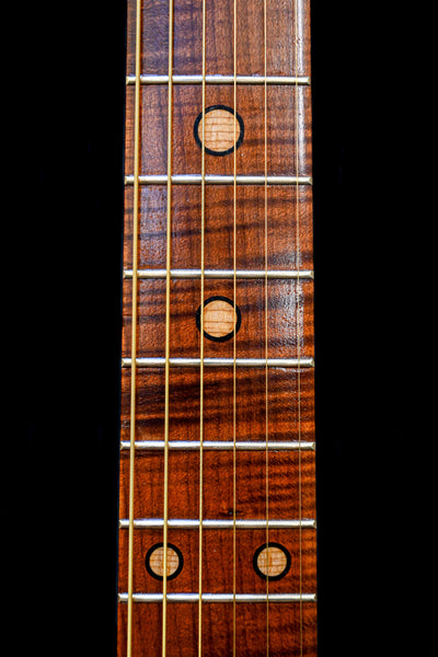 Close-up of the fretboard on M7 Heritage Red Cedar guitar by Belforti Instruments, highlighting the unique inlay design and polished strings.