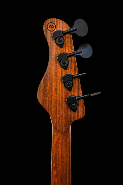 Image of the headstock of the E1 Normandy Apple Red bass guitar by Belforti Instruments, featuring tuning pegs and rich wood texture.