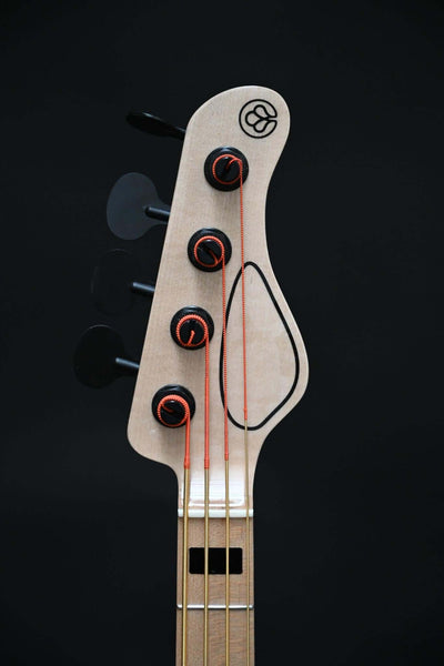 Headstock of Vēa 4 - Essential bass guitar by Belforti with wooden tonewood and tuning pegs, showcasing the instrument's simplicity and quality.