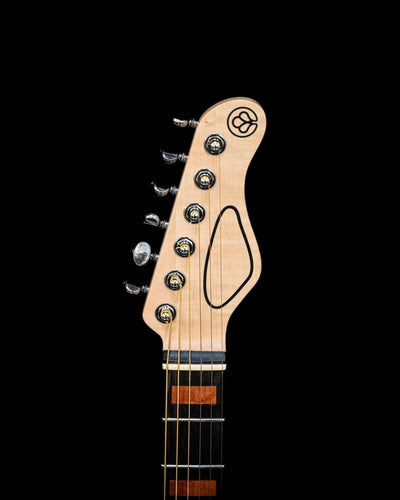 Headstock of the M7 - Makore guitar, featuring tuning pegs and logo against a black backdrop.