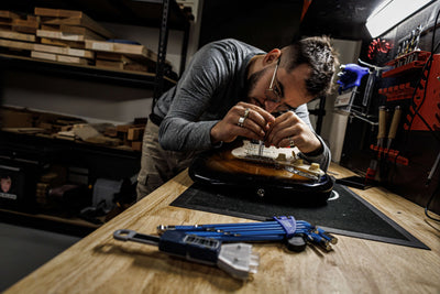 Luthier Marin Nourry Belforti Performing a setup on an electric guitar at Belforti Instruments Paris