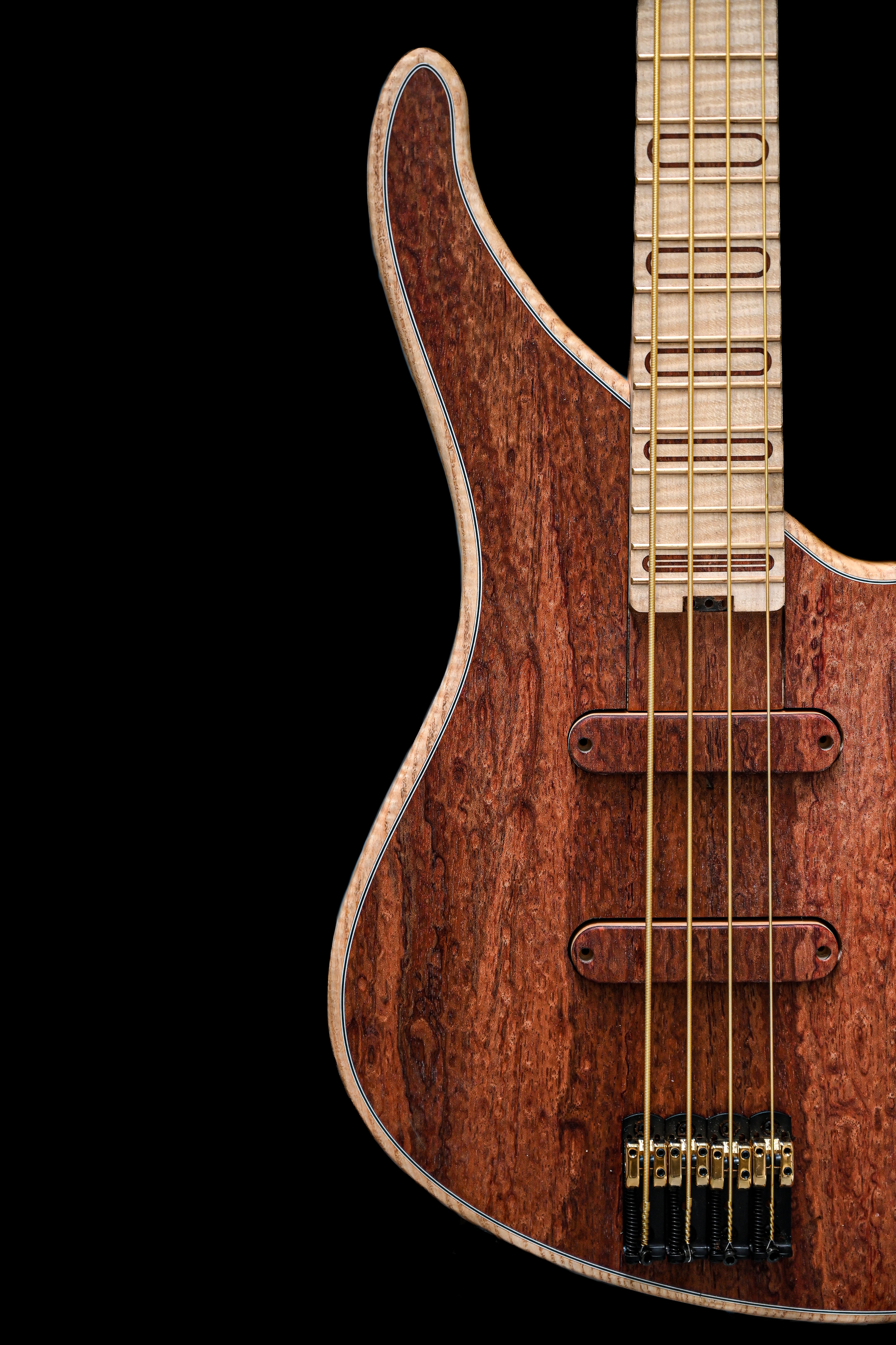 Close-up of the S1 Waterfall Bubinga bass guitar body, emphasizing the distinct patterns in the bubinga wood.