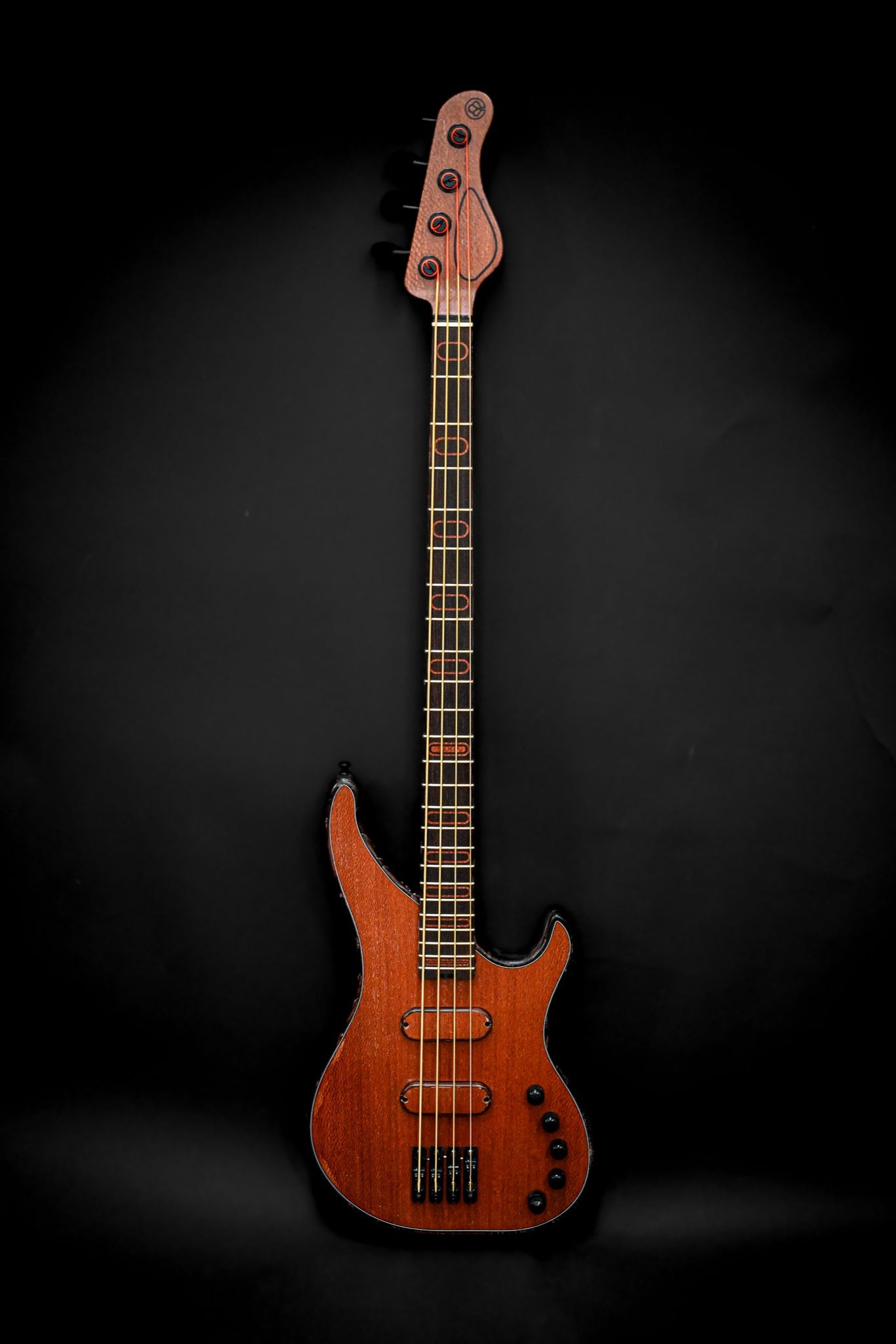 S3 Lacewood E-Bassgitarre, die ihre elegante Spitzenholzdecke und ihr schlankes Design vor einem schwarzen Hintergrund zur Geltung bringt.