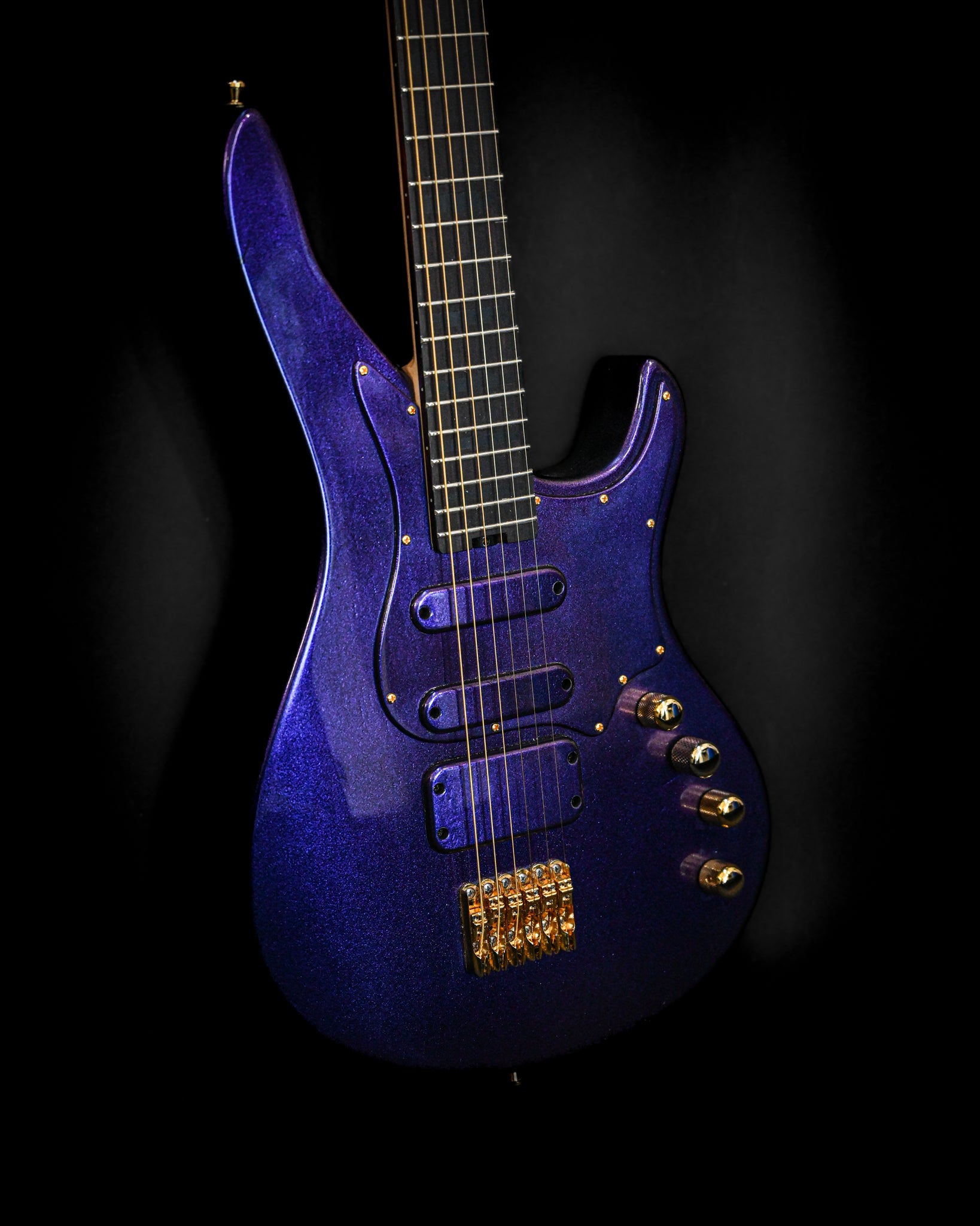 E7 - Cosmo (Colorshift) Gitarre, die angewinkelt ist, um die detaillierte Elektronik und die farbverändernde Lackierung zu zeigen.
