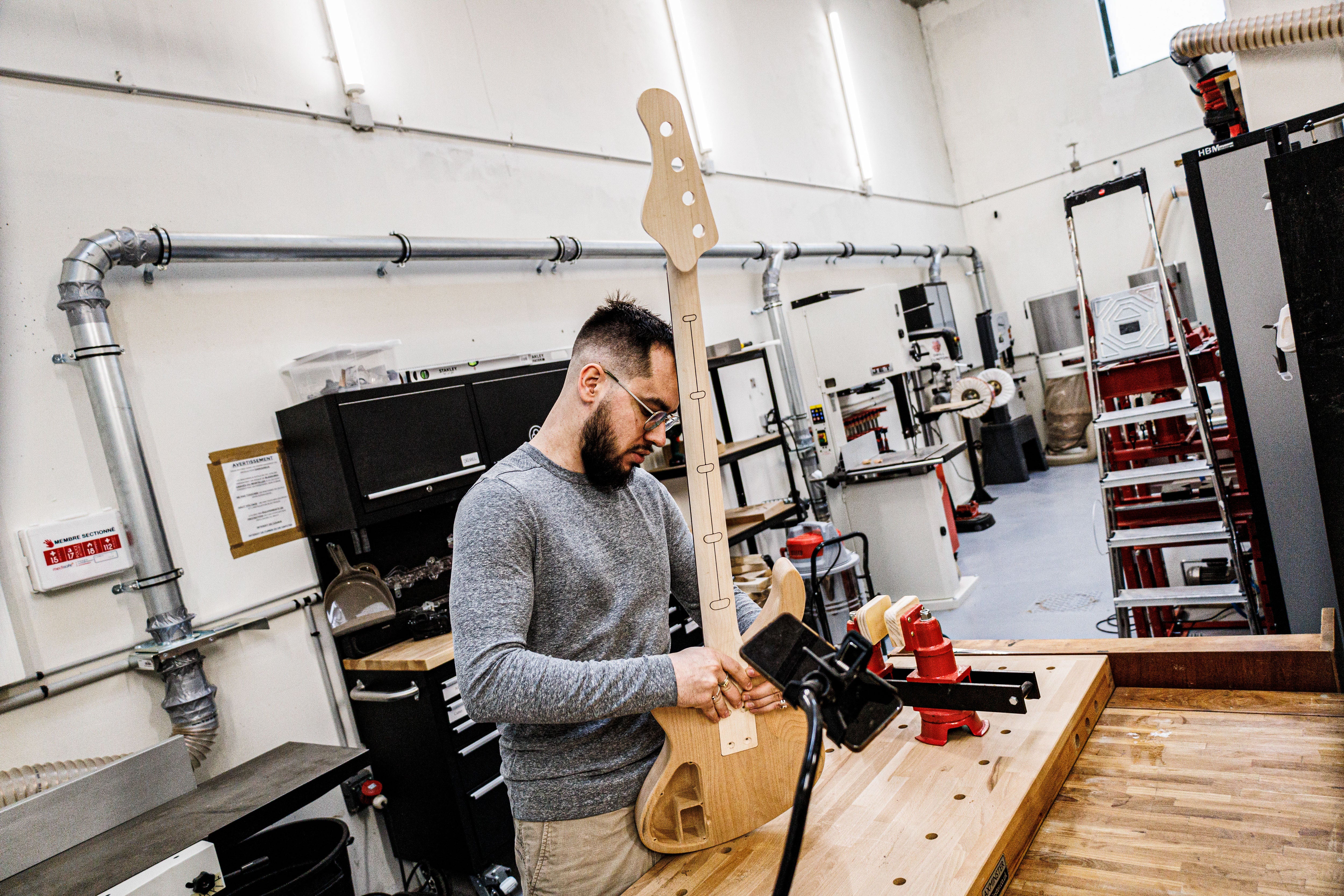 Geigenbauer Marin Nourry-Belforti bei der Handarbeit an einem Boutique-Bass der E-Serie in der Belforti-Manufaktur in Paris, Frankreich