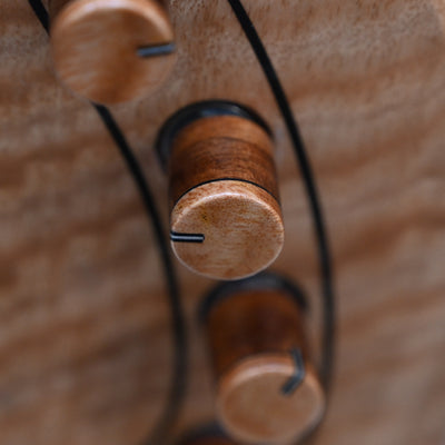 Primer plano de Marē 4: botones para bajo Masterbuilt fabricados por Belforti, que destacan por su artesanía de primera calidad y su sofisticado diseño.