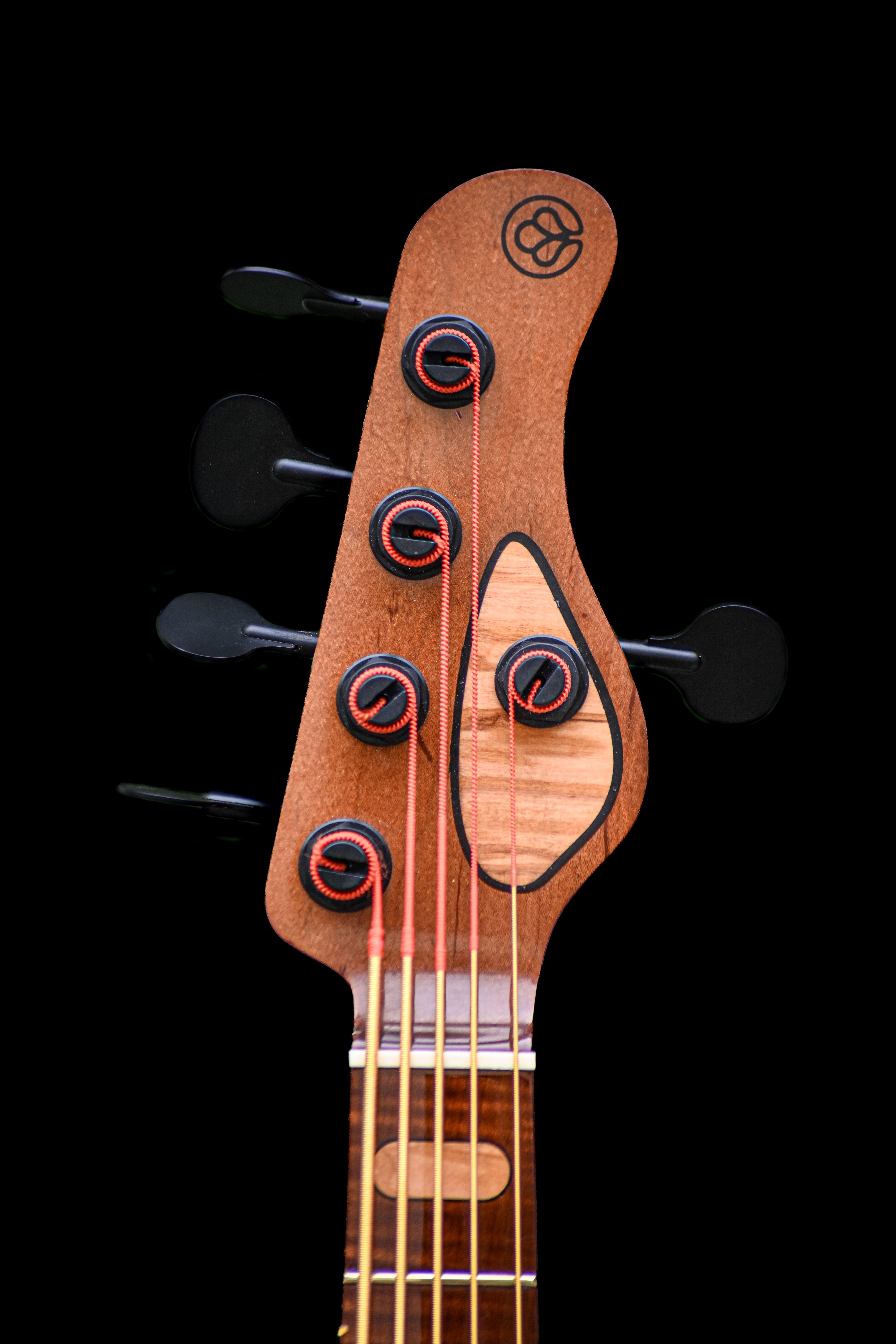 Clavijero del bajo M3 - Italian Olive, con clavijas de afinación y el logotipo artesanal.