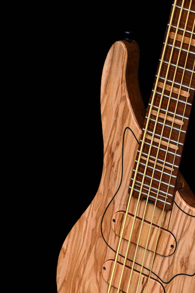 Primer plano de un Belforti Vēa 5: bajo Masterbuilt con cuerpo de madera de primera calidad y herrajes personalizados.