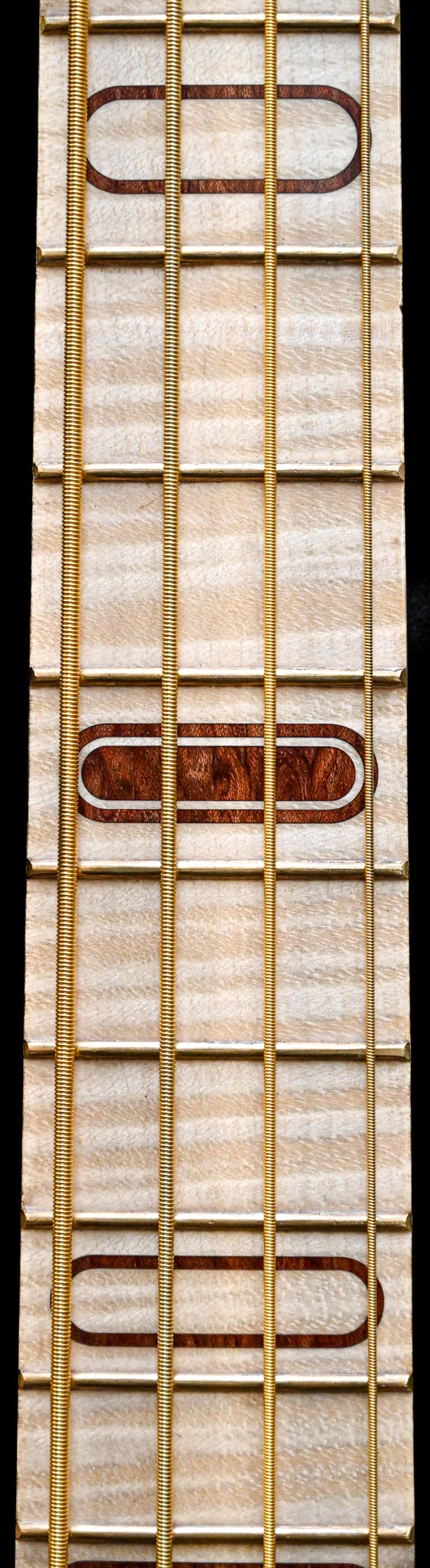 Primer plano del diapasón del bajo S1 Waterfall Bubinga, que ilustra la calidad de los materiales utilizados.