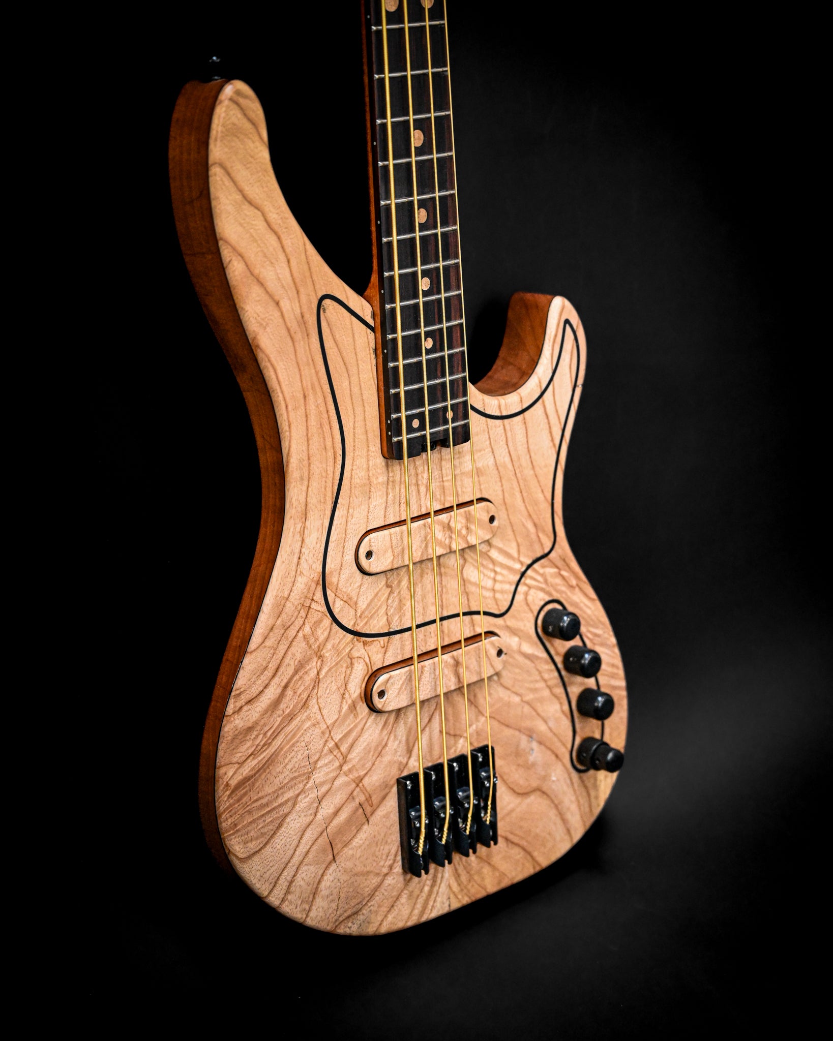 Primer plano del bajo M3 Maple en el que destacan sus controles y cuerdas.