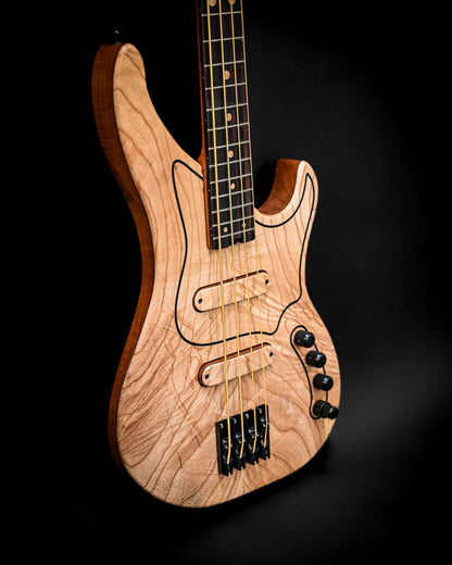 Primer plano del bajo M3 Maple en el que destacan sus controles y cuerdas.
