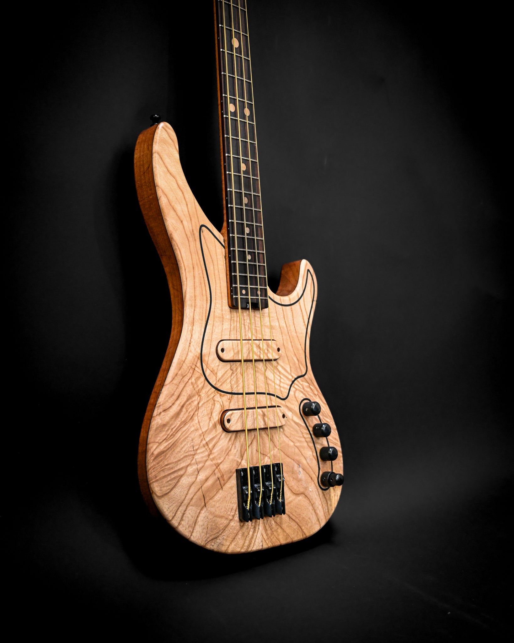Bajo M3 Maple en exhibición, mostrando su diseño y elegante acabado en una pose dramática.