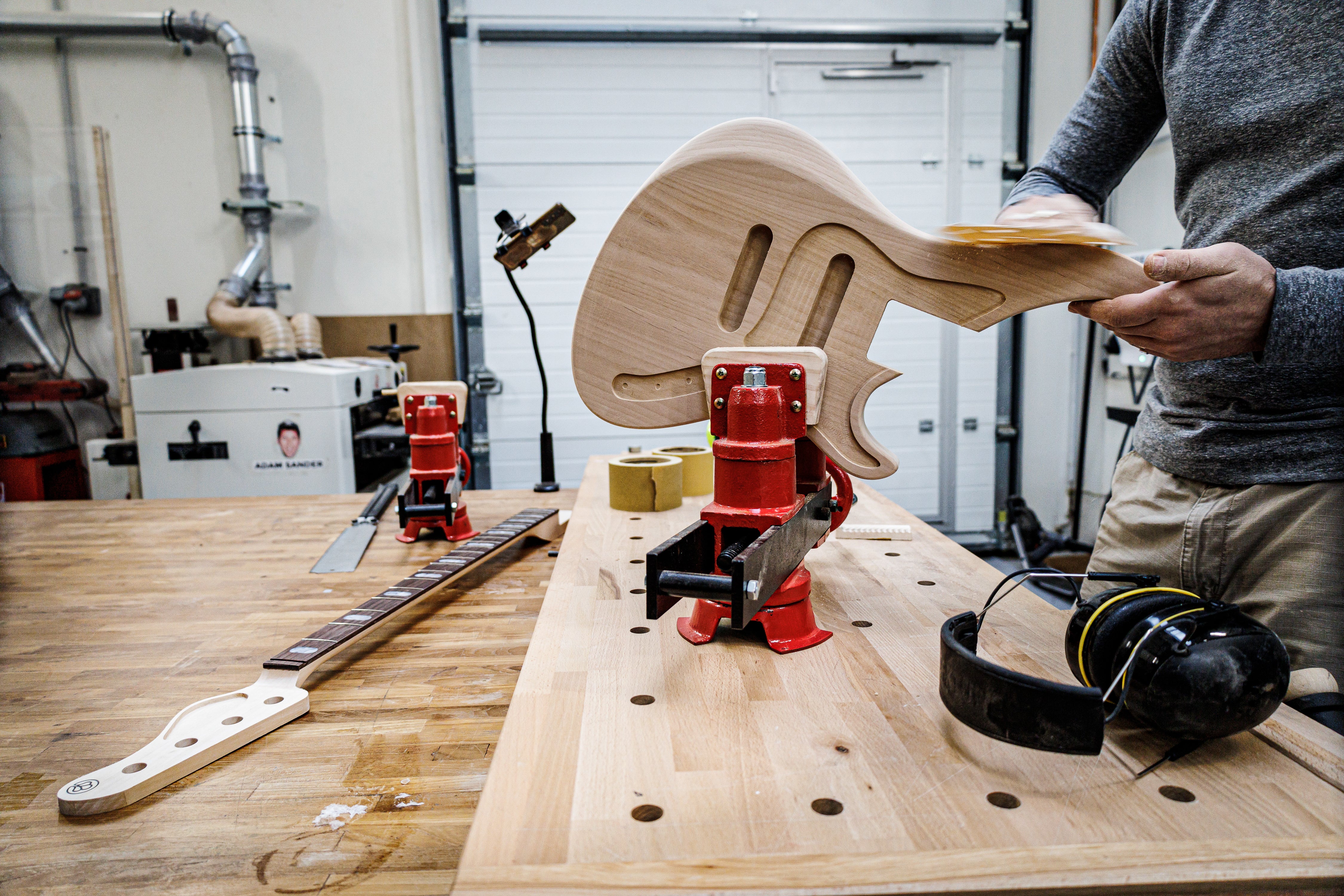 Fabrication d'un corps de guitare lors du cours de 3 semaines de construction de guitares et de basses dans l'atelier de Paris avec des outils et des composants.