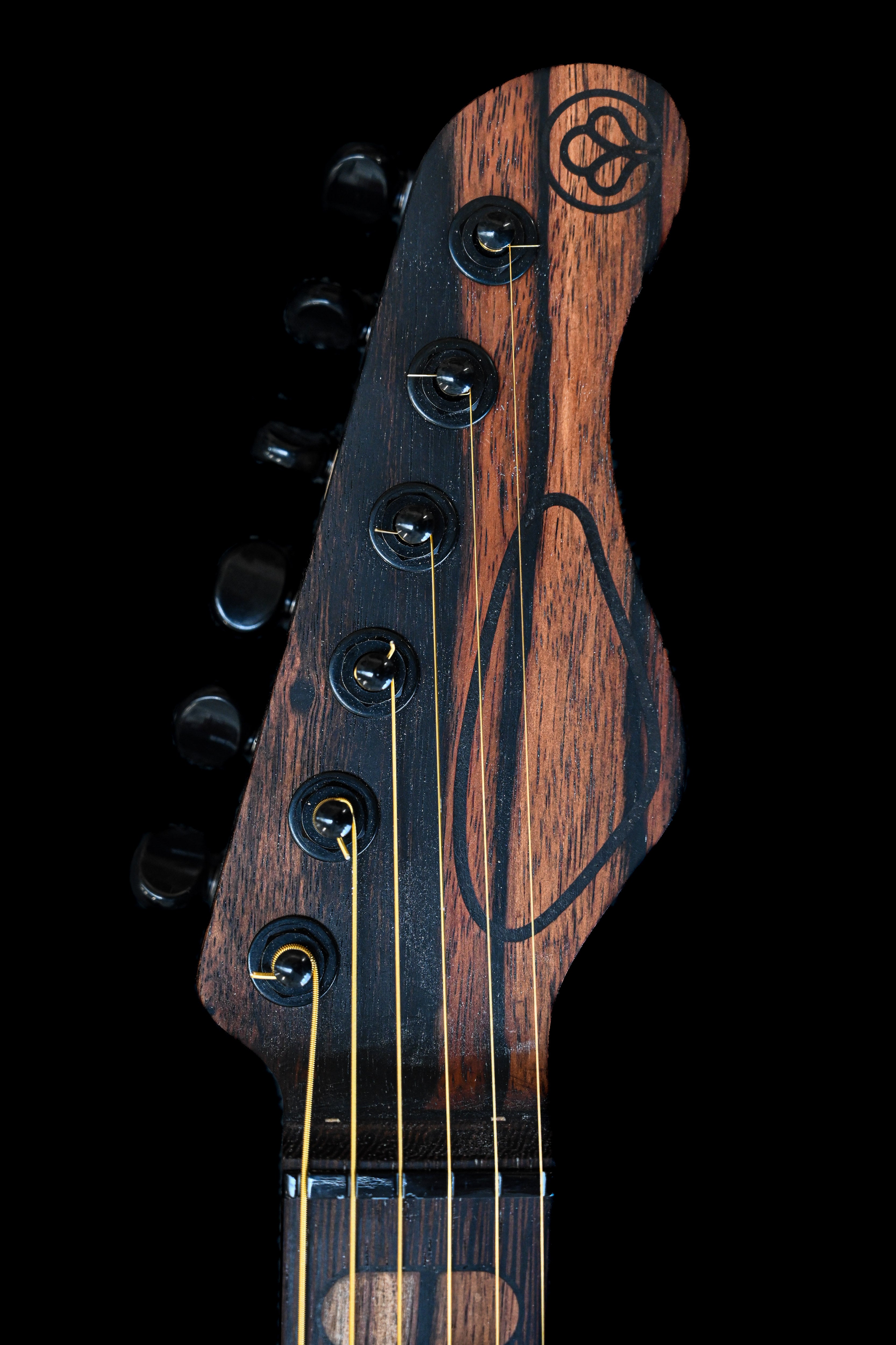 Gros plan détaillé de la guitare M-Series M5 de Belforti Instruments, mettant en évidence les motifs uniques du bois et les incrustations élégantes.