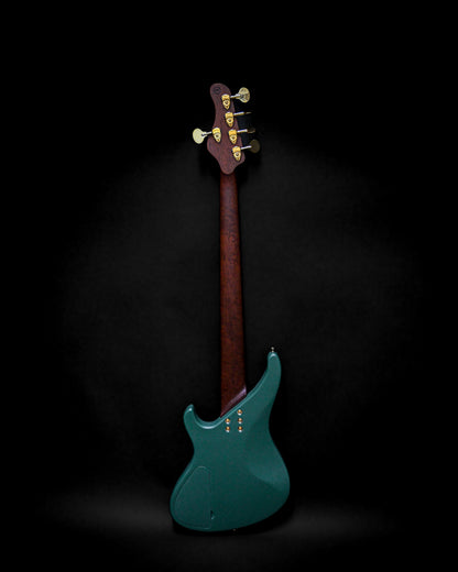 Dos d'une guitare basse électrique avec un corps vert foncé et un manche en bois sur fond noir.
