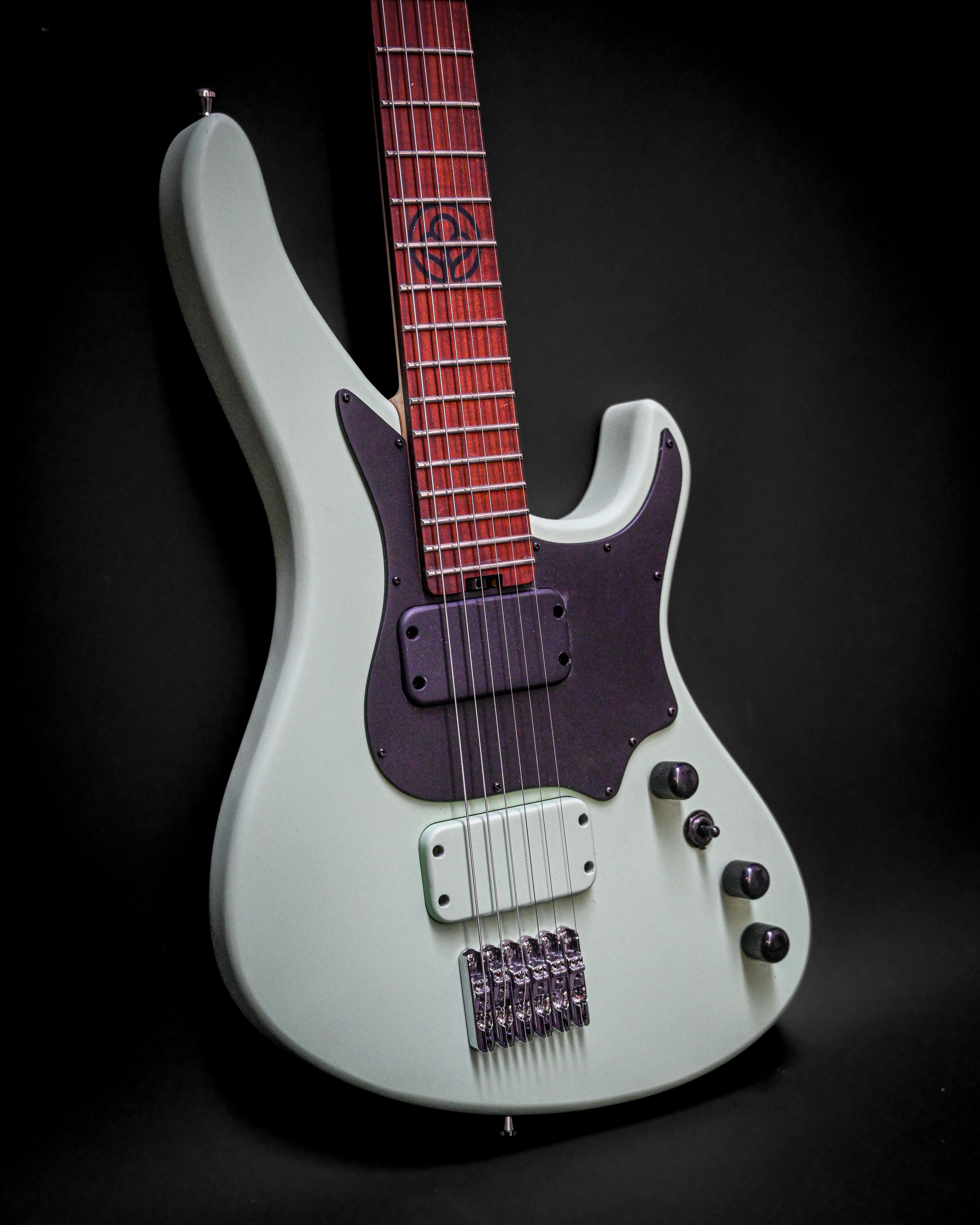 Guitare électrique avec corps blanc et manche rouge sur fond noir, avec pickguard noir et accastillage chromé.