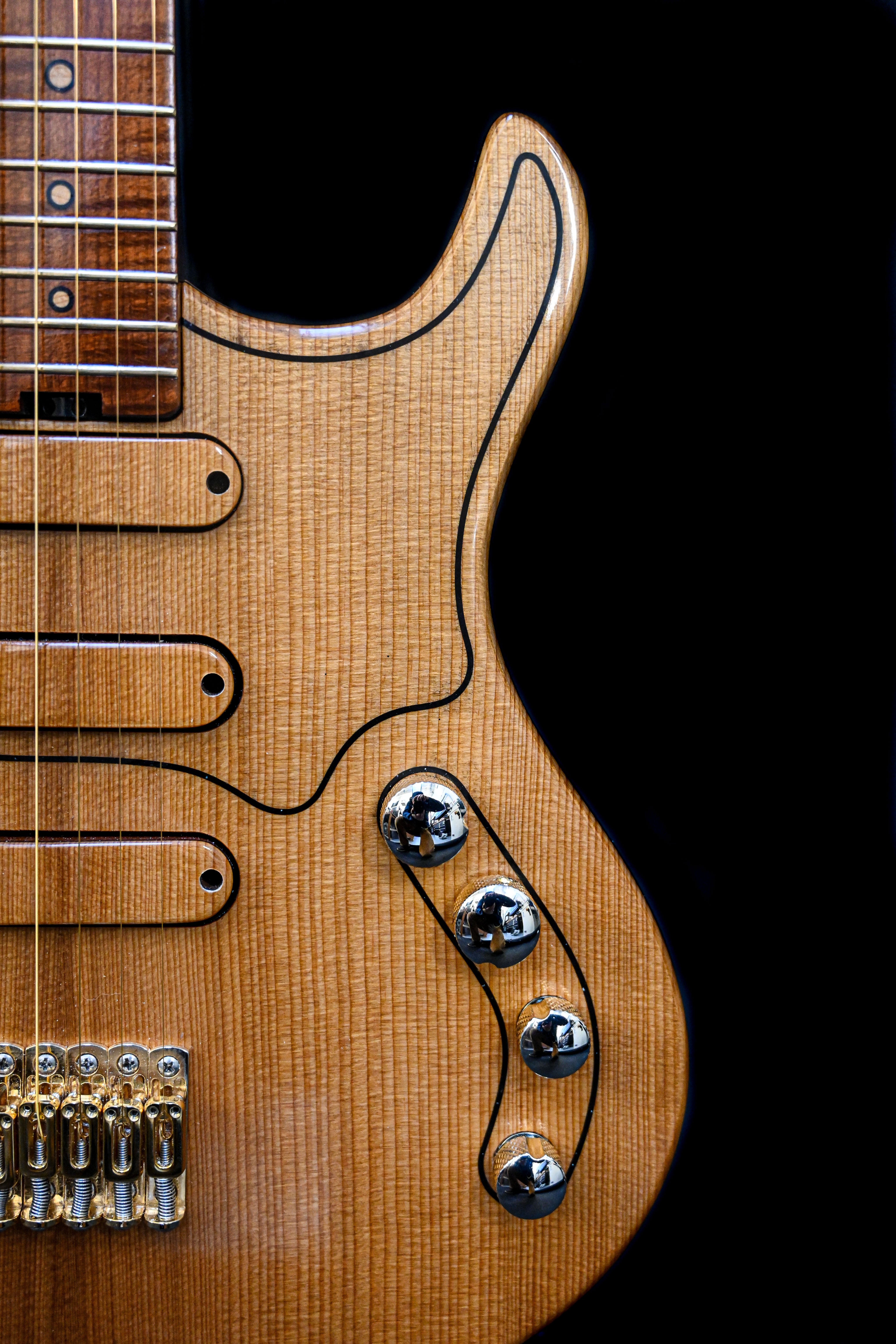 Vue latérale de la guitare M-Series de Belforti Instruments, mettant en valeur la finition en bois de première qualité et les éléments de conception élégants.